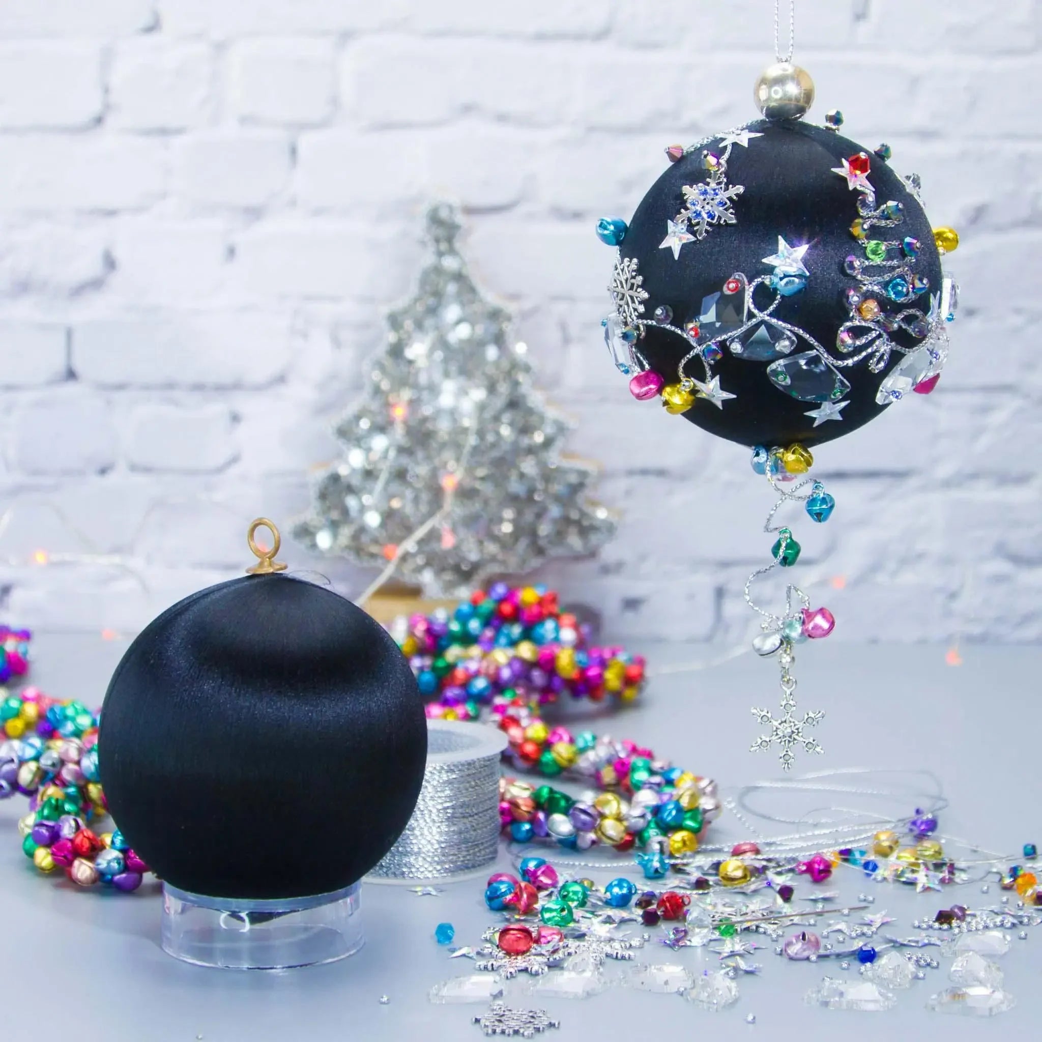Jingle Bells Satin Ornament -Black DIY Christmas push pin kit, featuring large glass beads, sparkling silver trim, sequins, and alloy snowflakes, set against a white brick backdrop.