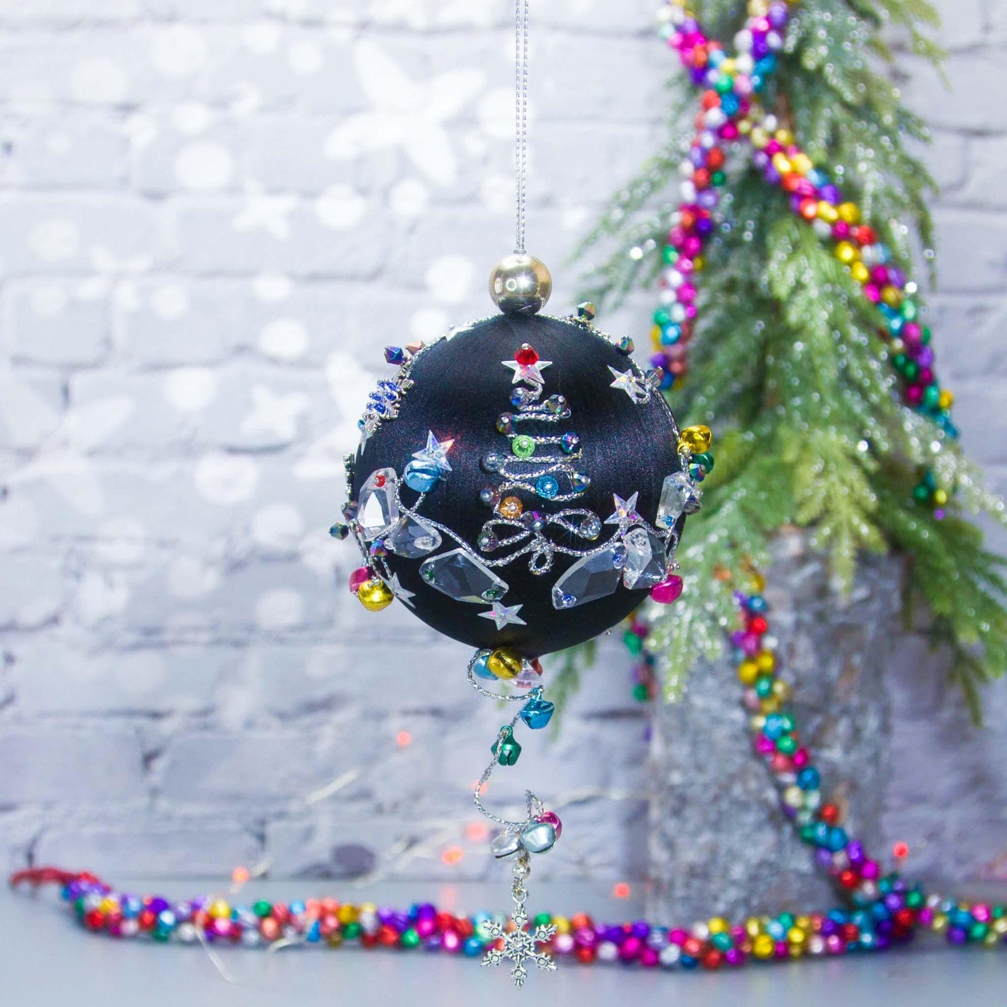 Jingle Bells Satin Ornament -Handmade Black Christmas Beaded Decoration, featuring large glass beads, sparkling silver trim, sequins, and alloy snowflakes, set against a small evergreen tree.