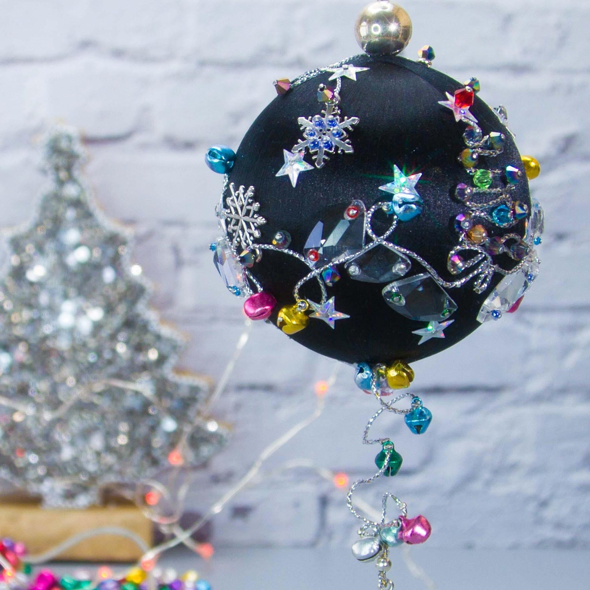 Jingle Bells Satin Ornament -Handmade Black Christmas Push Pin Decoration, featuring large glass beads, sparkling silver trim, sequins, and alloy snowflakes, set against a white brick backdrop.