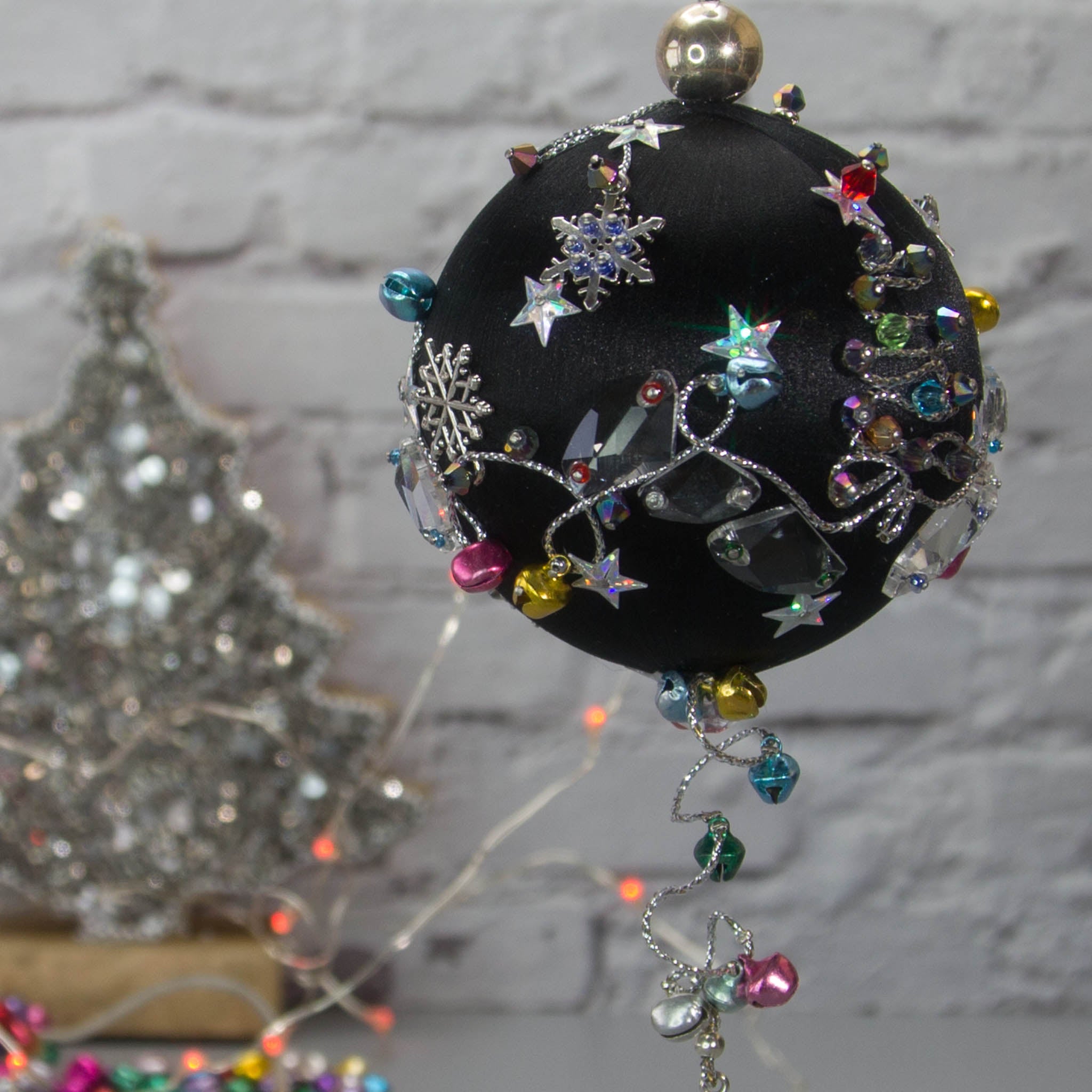 Jingle Bells Satin Ornament -Handmade Black Christmas Push Pin Decoration, featuring large glass beads, sparkling silver trim, sequins, and alloy snowflakes, set against a white brick backdrop.
