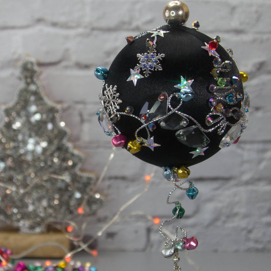 Jingle Bells Satin Ornament -Handmade Black Christmas Push Pin Decoration, featuring large glass beads, sparkling silver trim, sequins, and alloy snowflakes, set against a white brick backdrop.