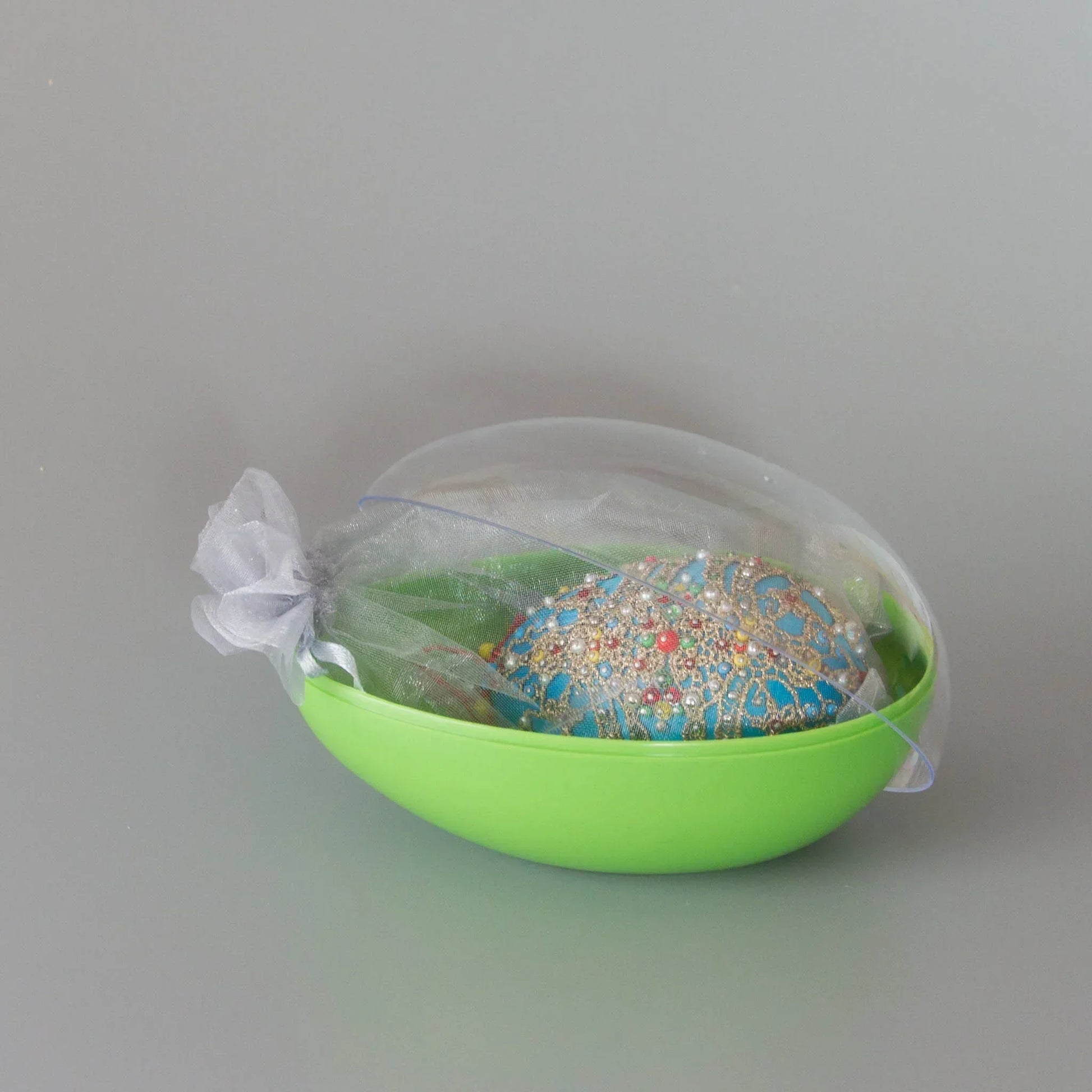Handmade satin ornament Misbah in organza bag packed in an egg-shaped container with a clear lid. (Sky Blue)