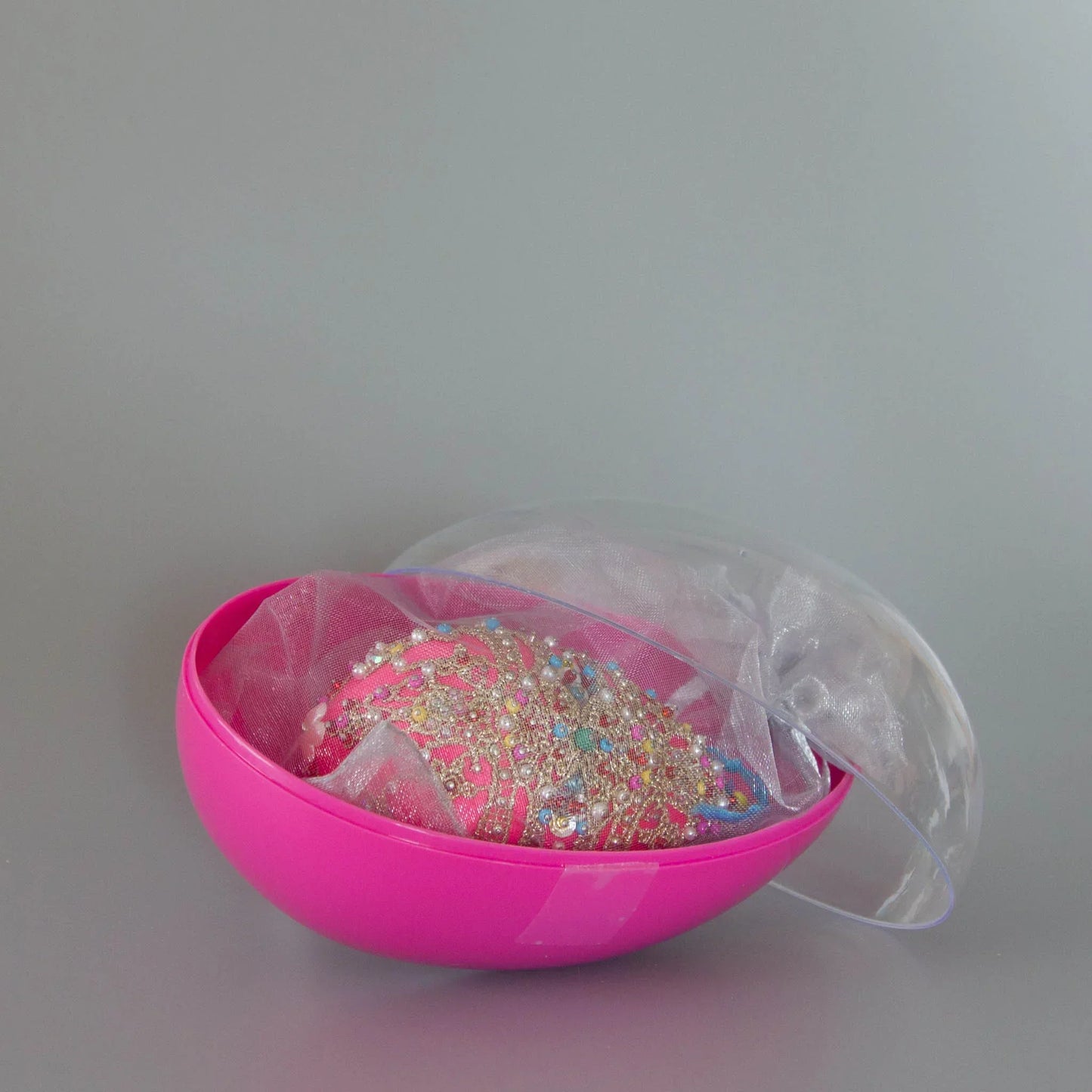 Hot pink handmade satin ornament Misbah in organza bag packed in an egg-shaped fuchsia container with a clear lid. (Deep Pink)