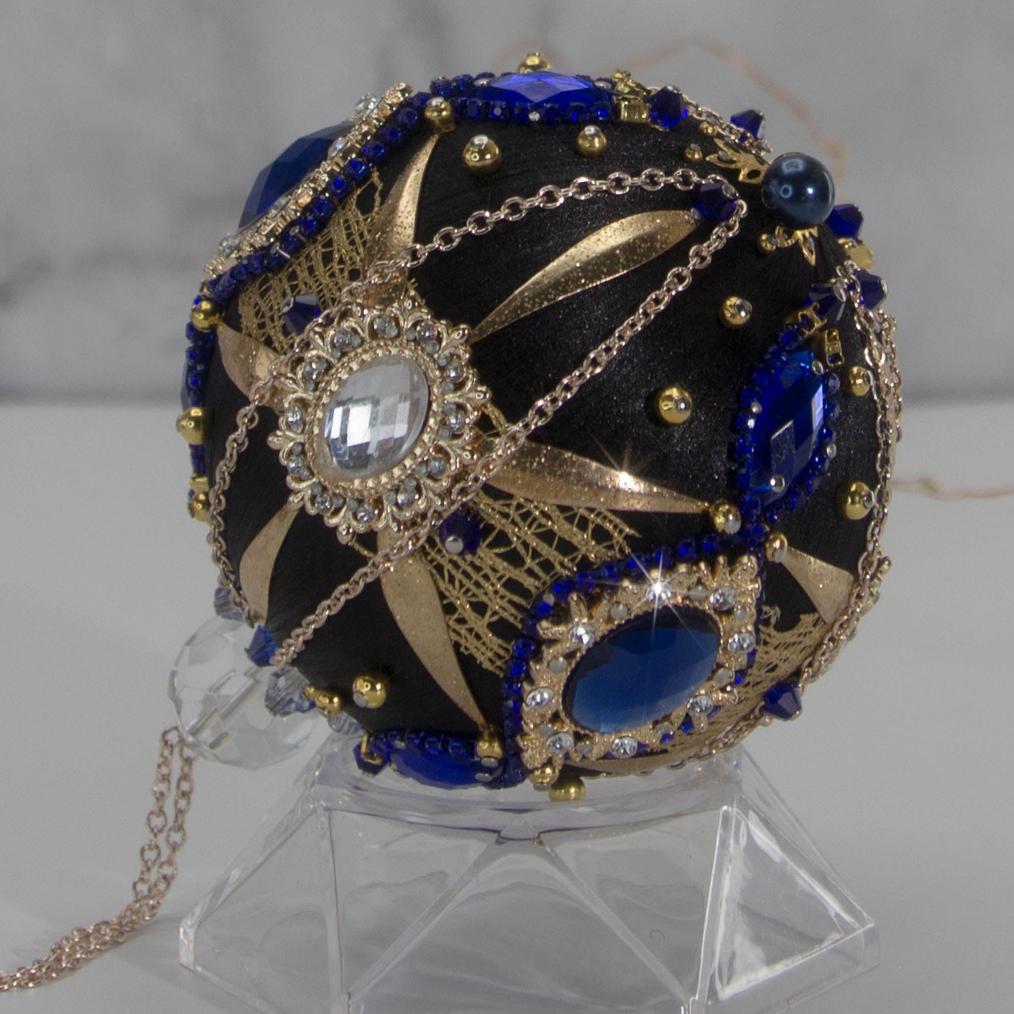Close-up of Phoenix Christmas Beaded Handmade Push Pin Ornament embellished with gold cameos, intense blue rhinestones, metal accents, and rose old chain. (Black)