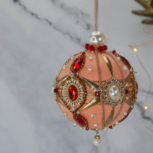 Side view of Phoenix Christmas Beaded Push Pin Satin Ornament features large cameos with red rhinestones, gold alloy accents, and gold chain. (Coral)