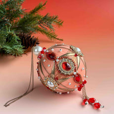 Festive Christmas ornament with red and gold cameos on a soft gradient background. (Coral)