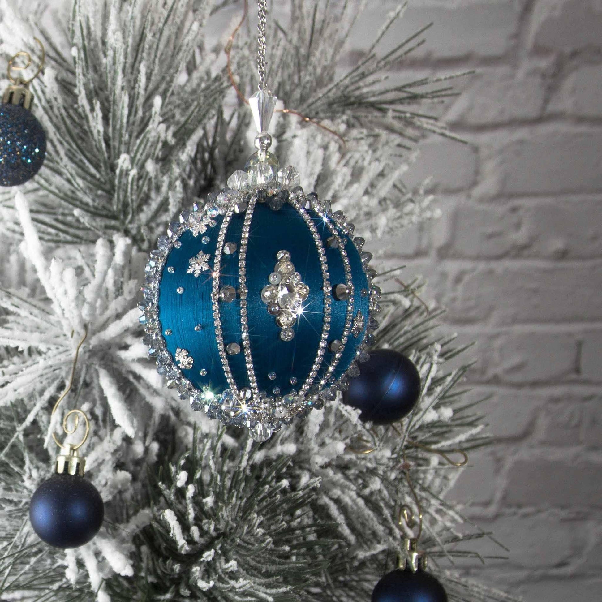 Polar Night Satin Kit-Dark Blue finished Christmas ornament in front of festive winter snowy covered evergreen tree.