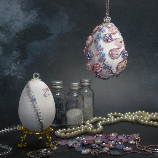 Princess Satin Egg Ornament -Elegant DIY Easter push pin kit, which includes sparkling beads, trims, and rhinestones, set against a dark background with flowers and a string of pearls.