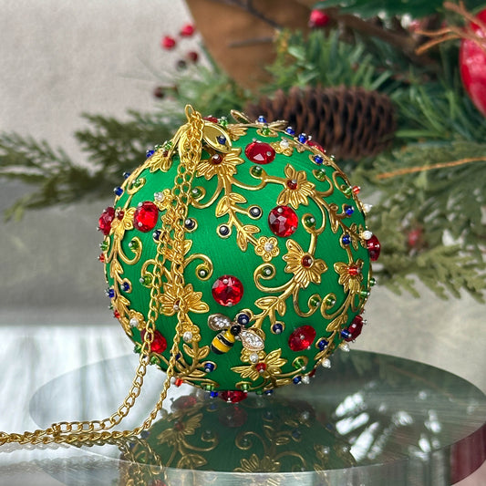 Quam Handmade Christmas Push Pin  Ornament in Green with gold metal embellishments and red rhinestones in front of evergreen branch. (Green)