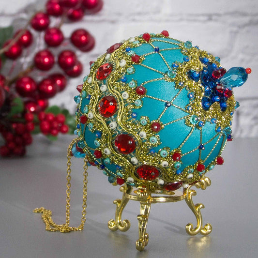 Close-up view of the bottom of Scheherazade  Handmade Satin Ornament - Teal colored Christmas push pin decoration, featuring red rhinestones, red bicone beads, sequins, and metallic cord. (Light Sea Green)