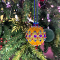 Load image into Gallery viewer, Scheherazade Handmade Satin Ornament -Festive mustard-colored ball with purple rhinestones, set against a Christmas tree with lights. (Gold) 
