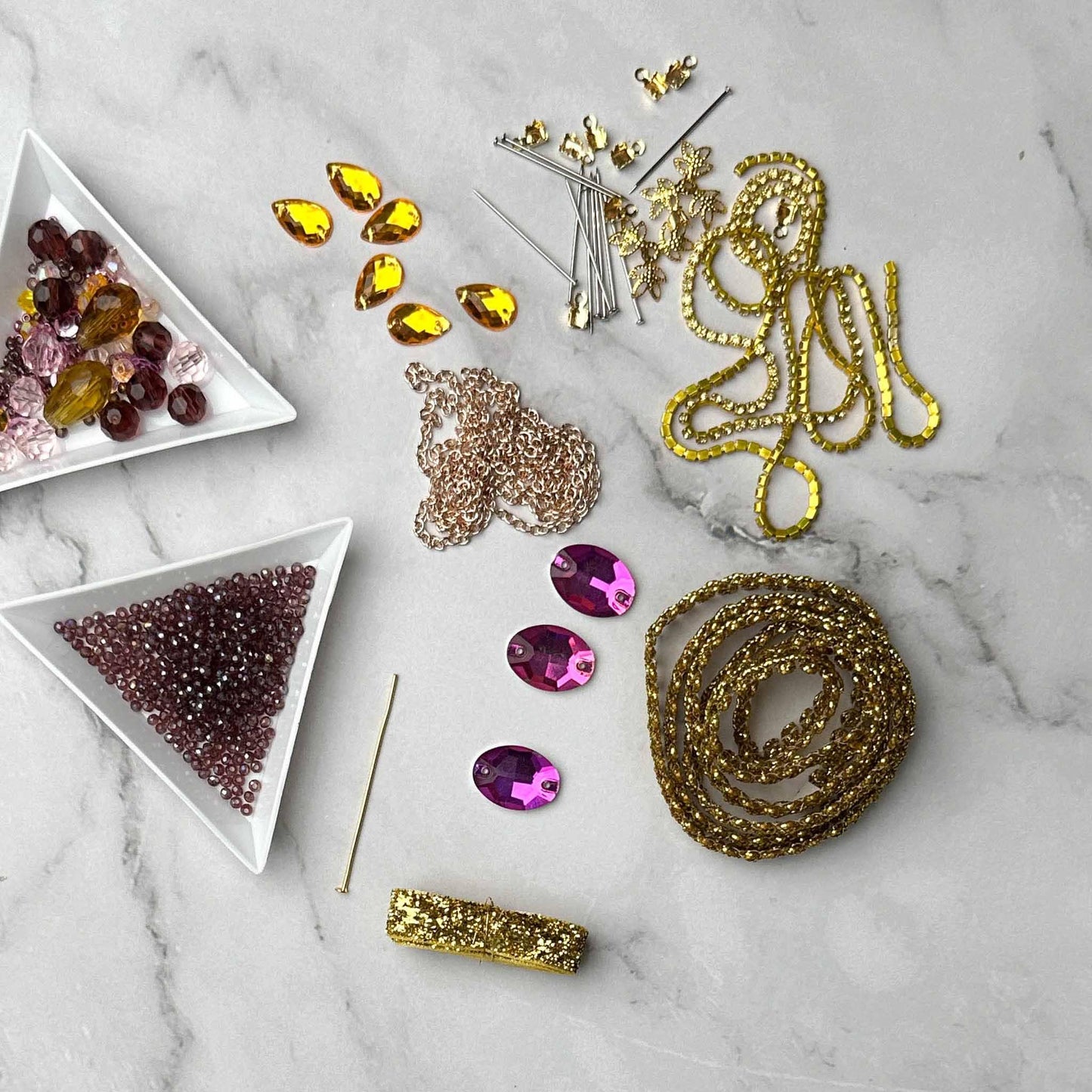 Materials to make Christmas Beaded Ornament by pinning glass rhinestones, gold braided trim, and crystal beads. to a satin ball. (Maroon).