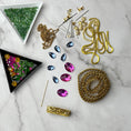 Load image into Gallery viewer, Materials to make Christmas Beaded Ornament by pinning glass rhinestones, gold braided trim, and crystal beads. to a satin ball. (Olive).
