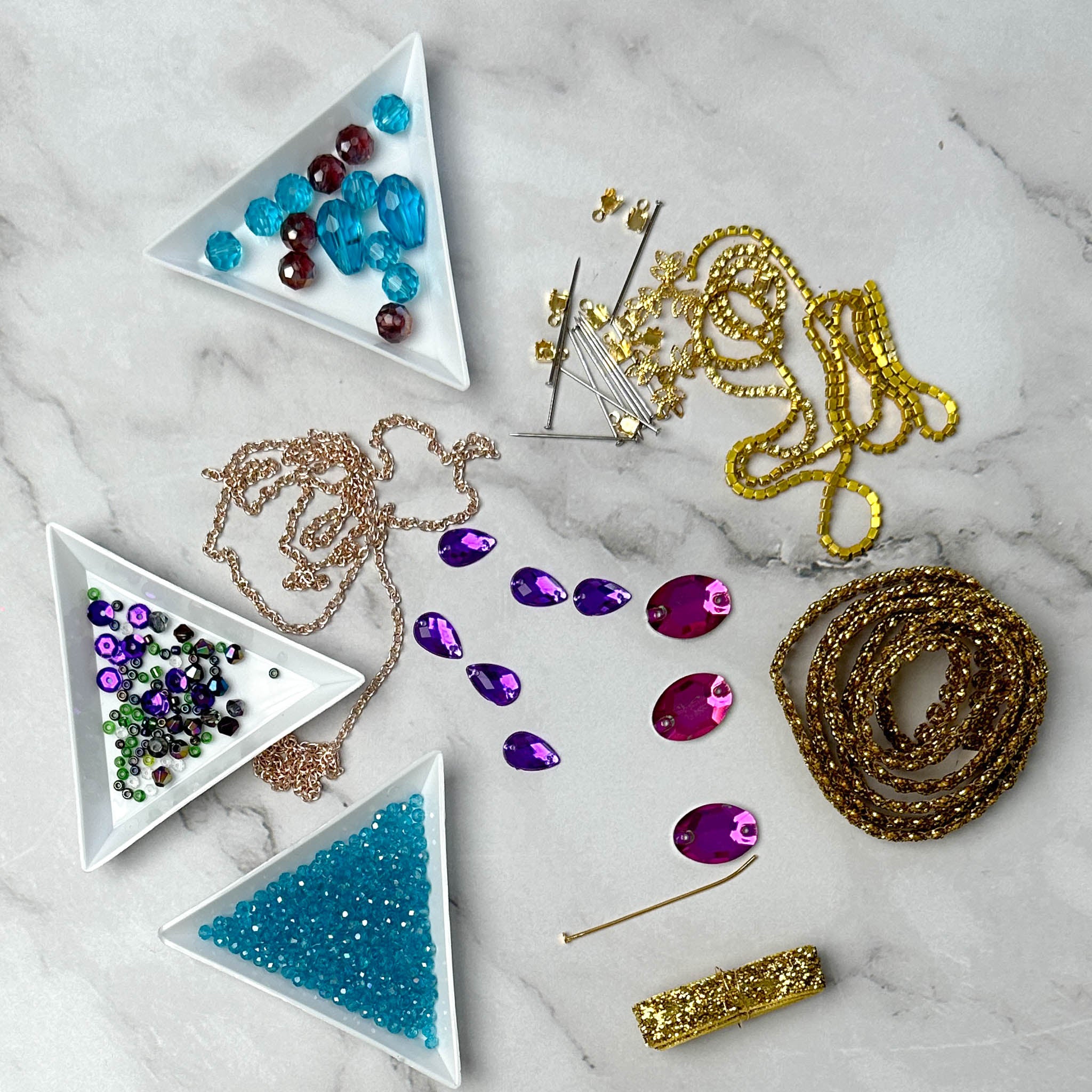 Materials to make Christmas Beaded Ornament by pinning glass rhinestones, gold braided trim, and crystal beads. to a satin ball. (Sky Blue).