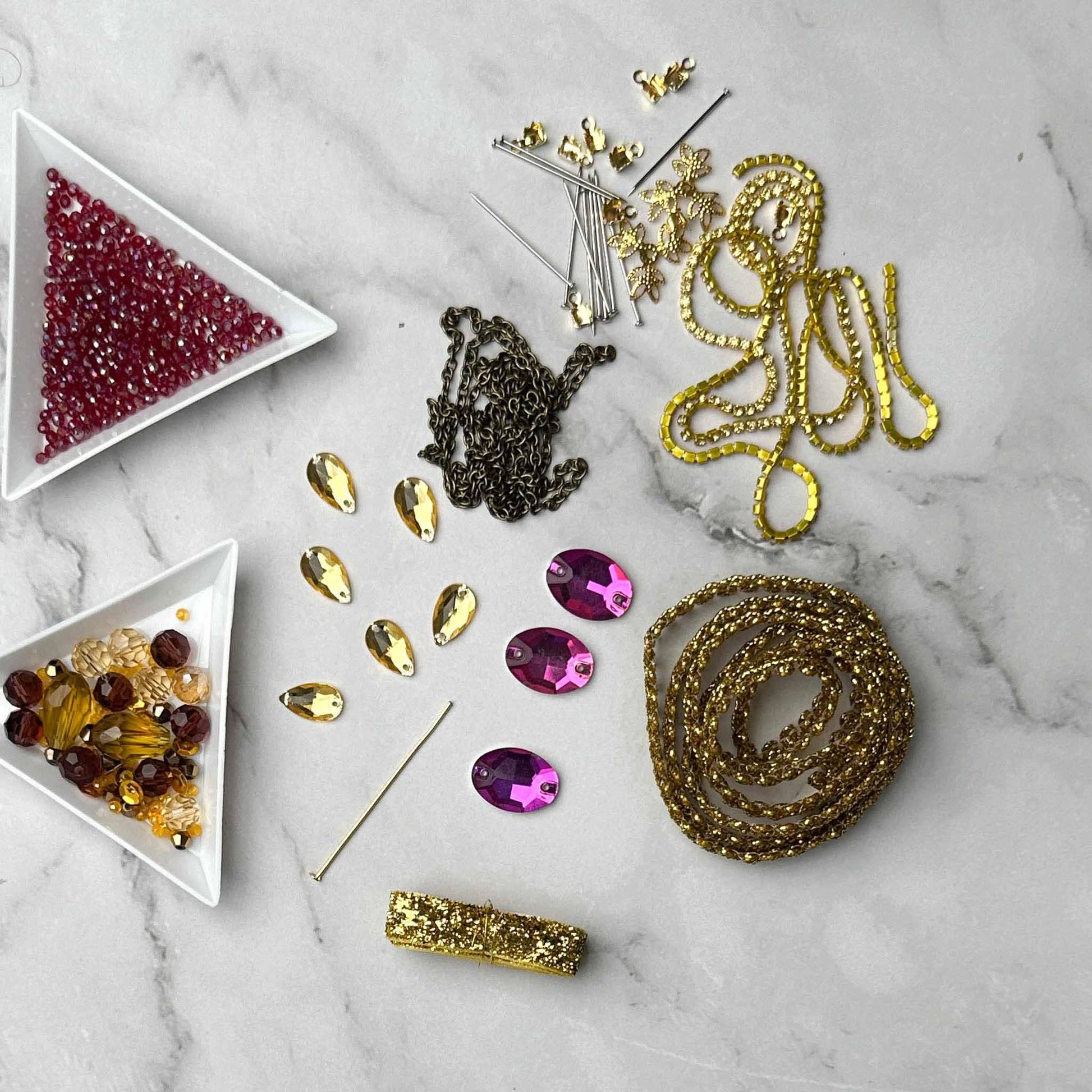 Materials to make Christmas Beaded Ornament by pinning glass rhinestones, gold braided trim, and crystal beads. to a satin ball. (White).