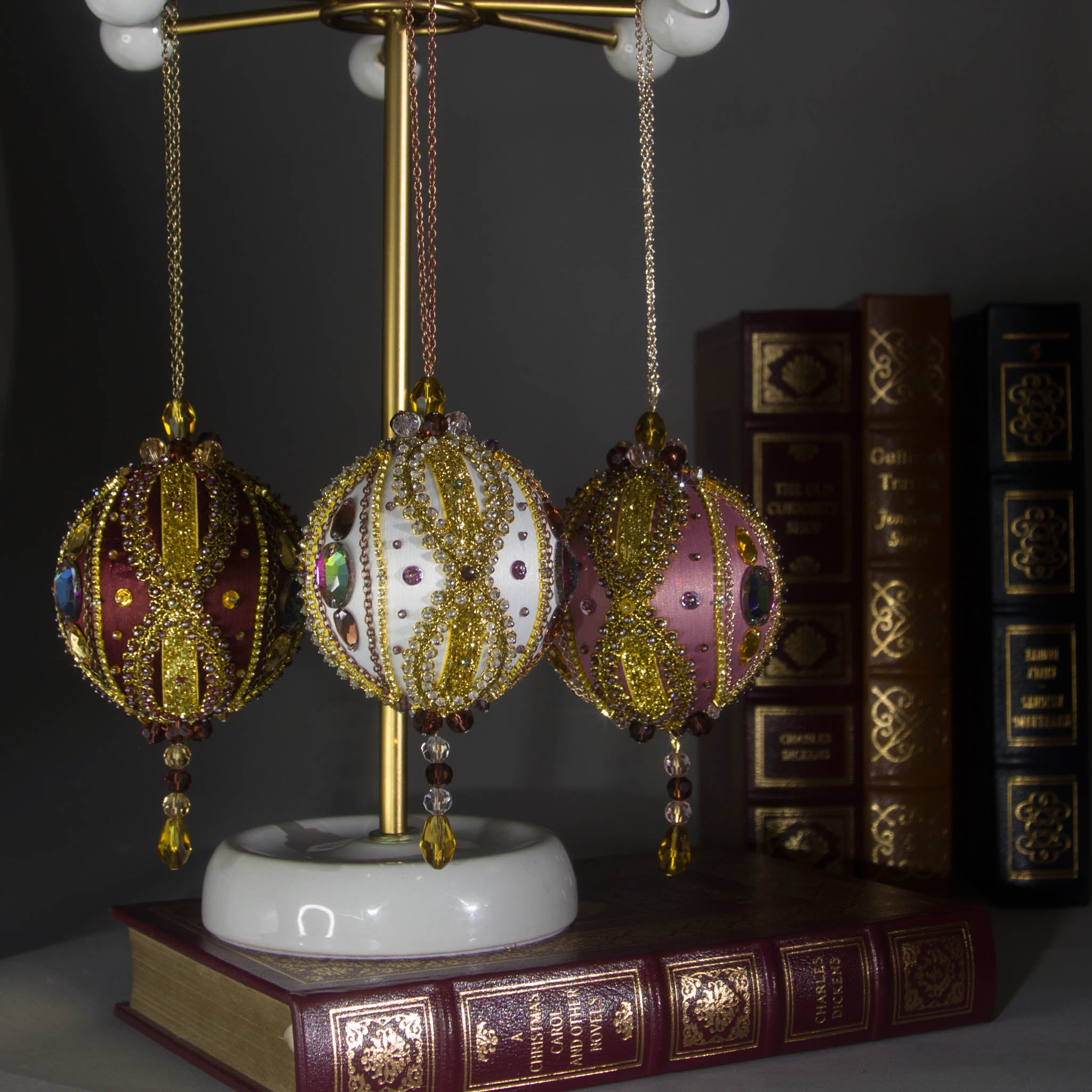 Collection of handmade Beaded Christmas Ornaments Uliger embellished with gold trim, color-shifting rhinestones, and sequins.