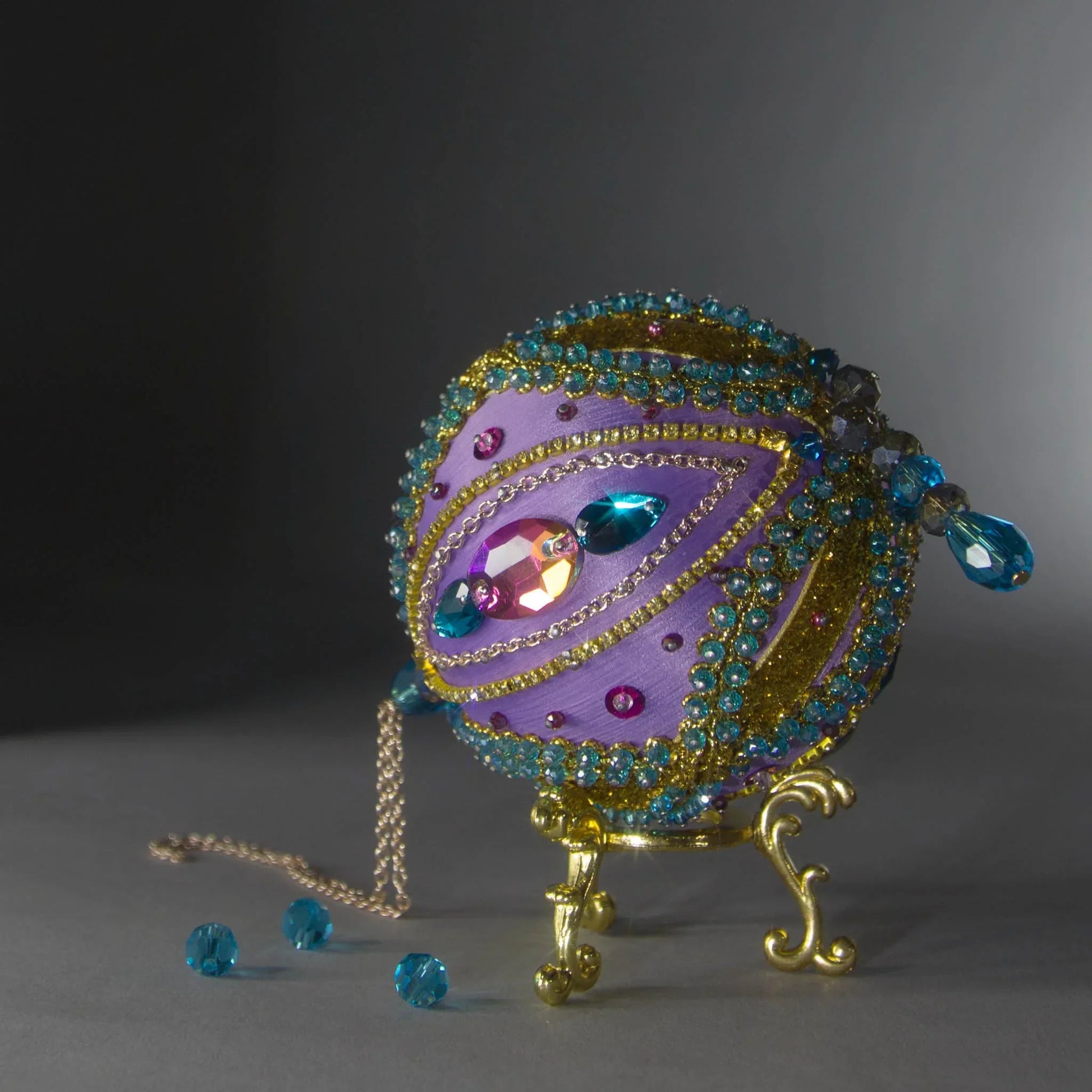 Christmas Beaded Ornament Kit Ball embellished with glass rhinestones, gold braided trim, and crystal beads. Bottom detail. (Medium Purple).