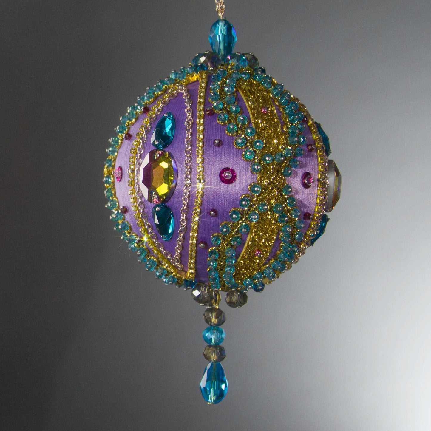 Christmas Beaded Ornament Kit Ball embellished with glass rhinestones, gold braided trim, and crystal beads. Front. (Medium Purple).