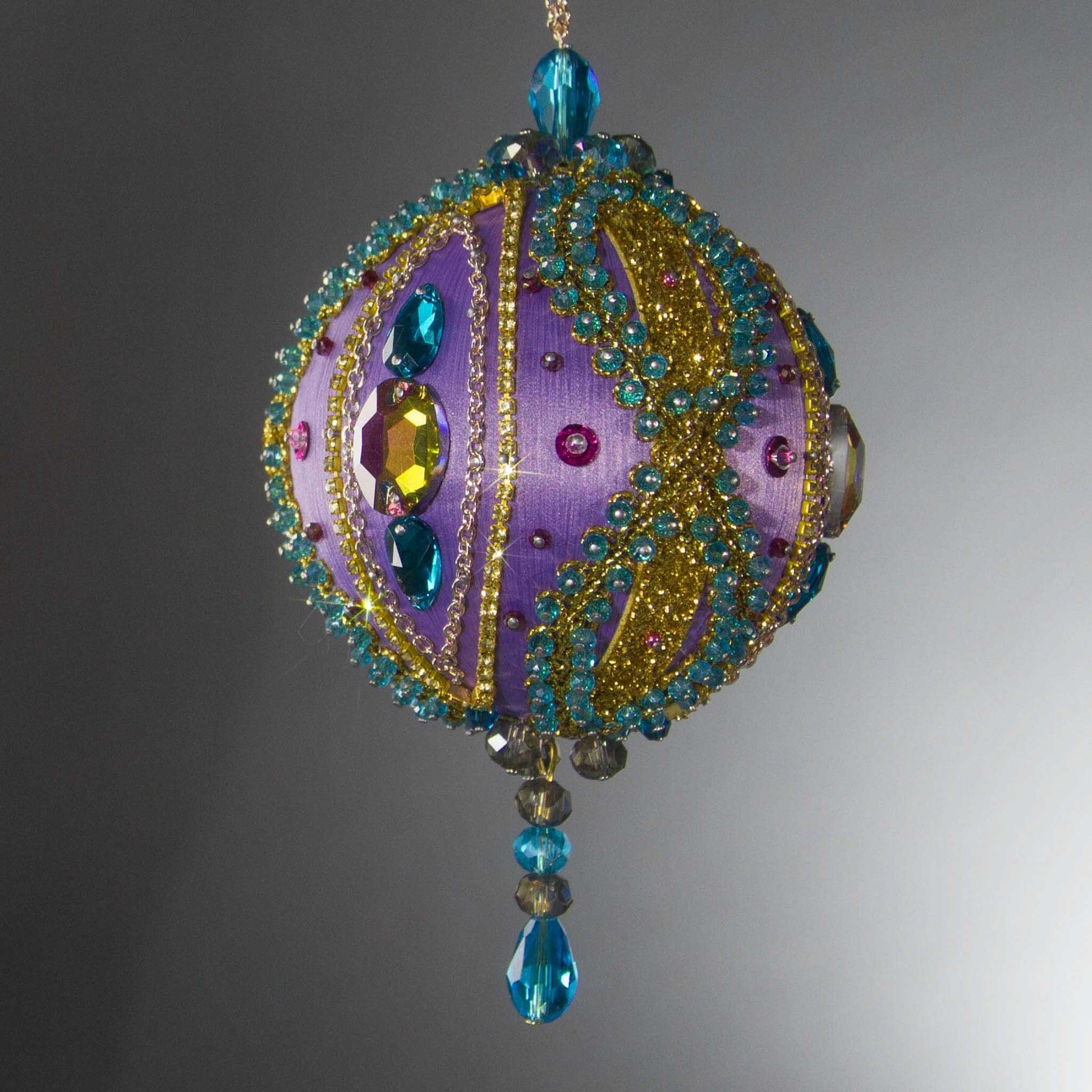 Christmas Beaded Ornament Kit Ball embellished with glass rhinestones, gold braided trim, and crystal beads. Front. (Medium Purple).