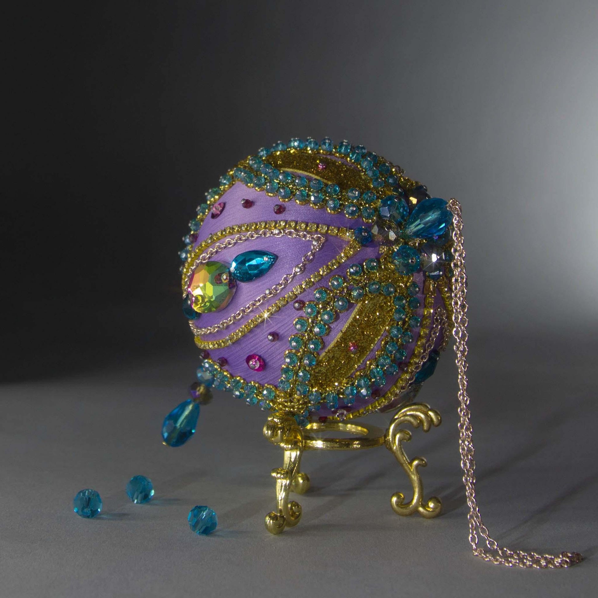 Christmas Beaded Ornament Kit Ball embellished with glass rhinestones, gold braided trim, and crystal beads. Top detail. (Medium Purple).