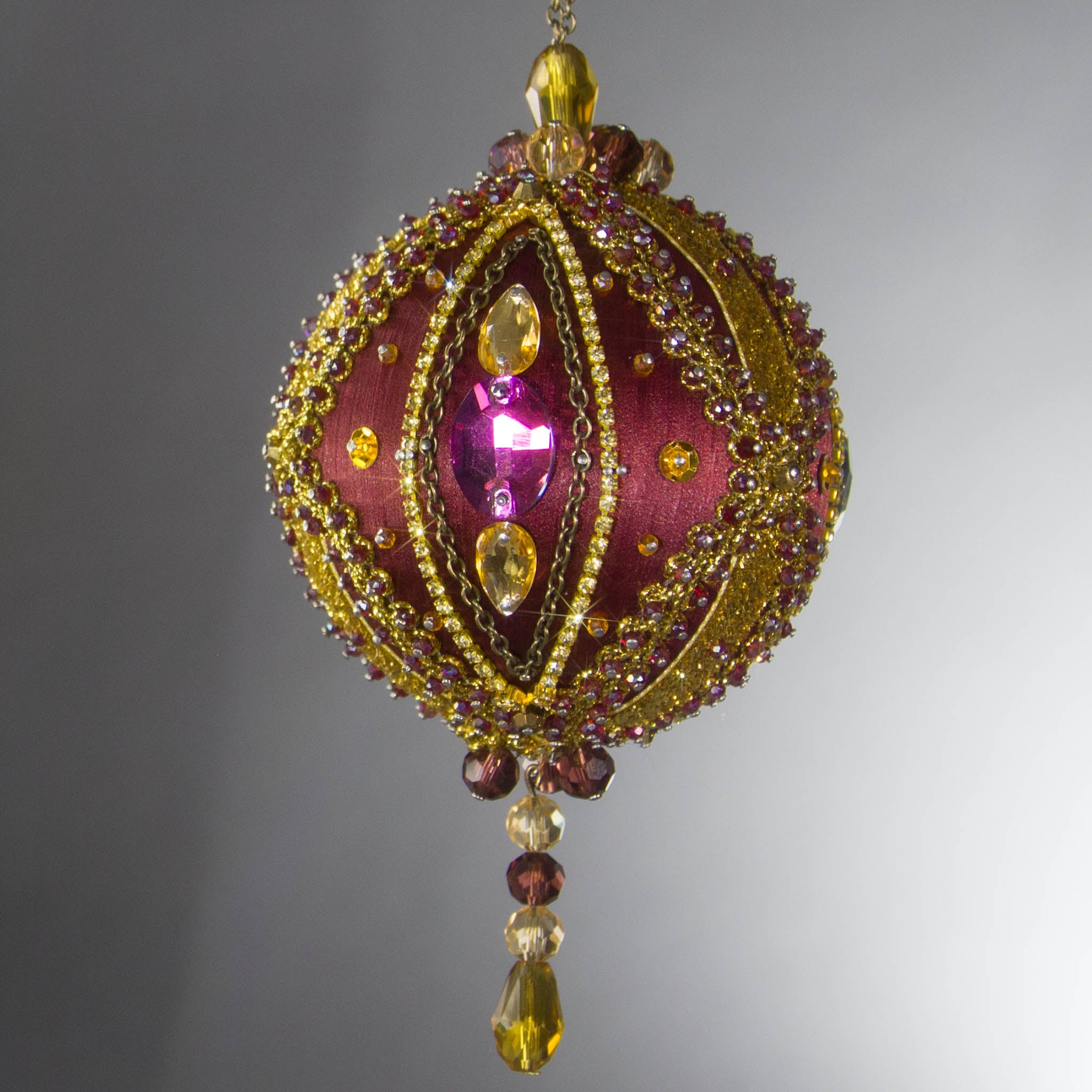 Handmade Satin Ornament by Whim5seasons, but also has a Kit to create a decoration embellished with glass rhinestones, gold braided trim, and crystal beads. Front. (Maroon).