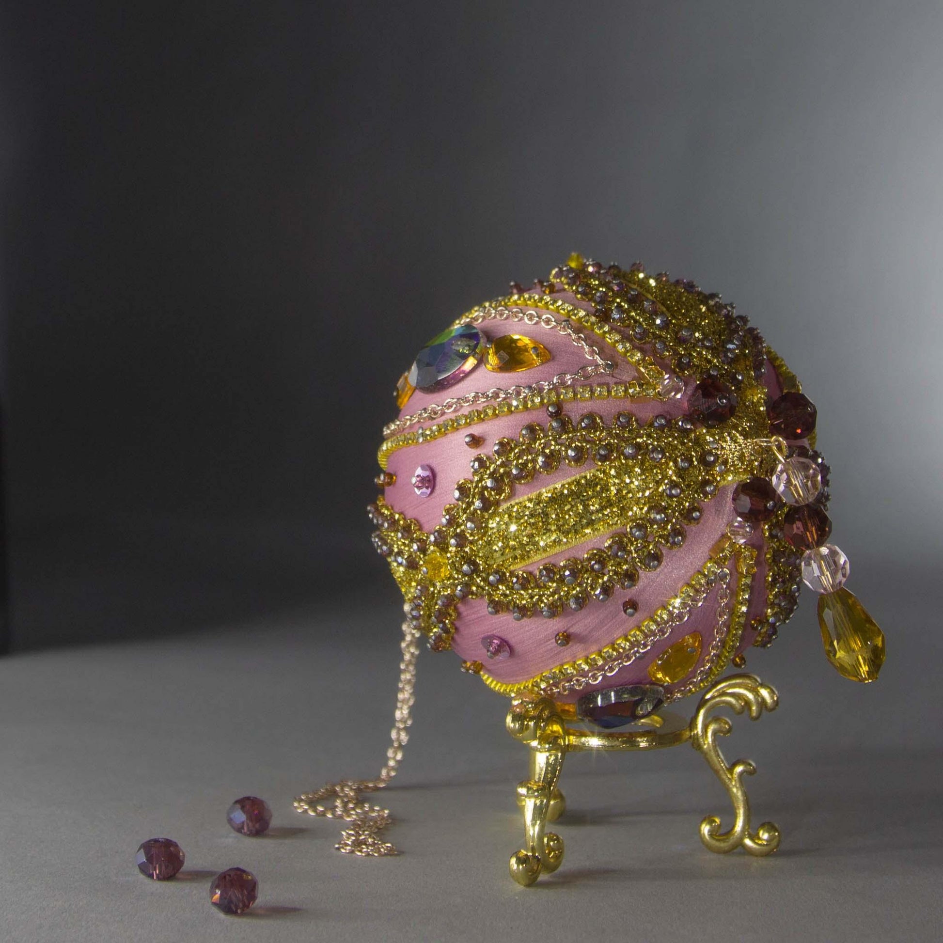 Christmas Beaded Ornament Kit Ball embellished with glass rhinestones, gold braided trim, and crystal beads. Bottom detail. (Pale Violet Red).