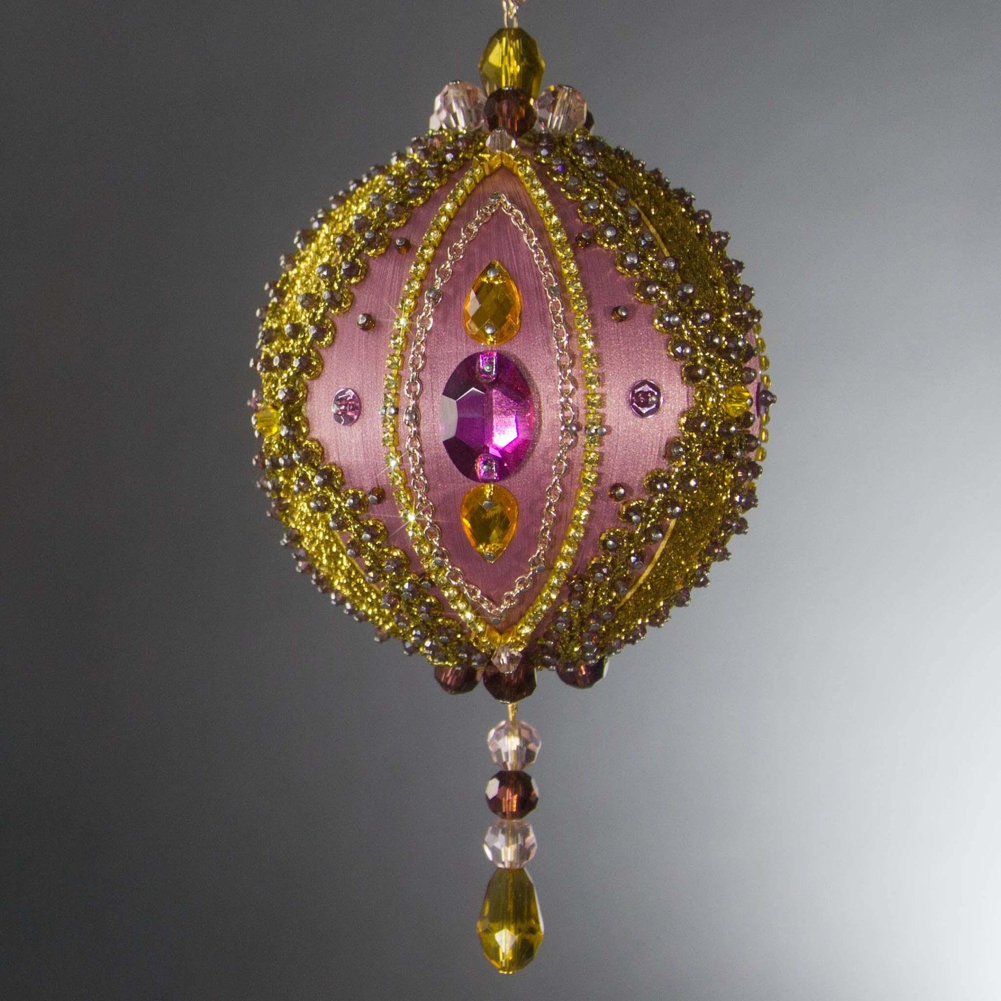 Christmas Beaded Ornament Kit Ball embellished with glass rhinestones, gold braided trim, and crystal beads. Front. (Pale Violet Red).