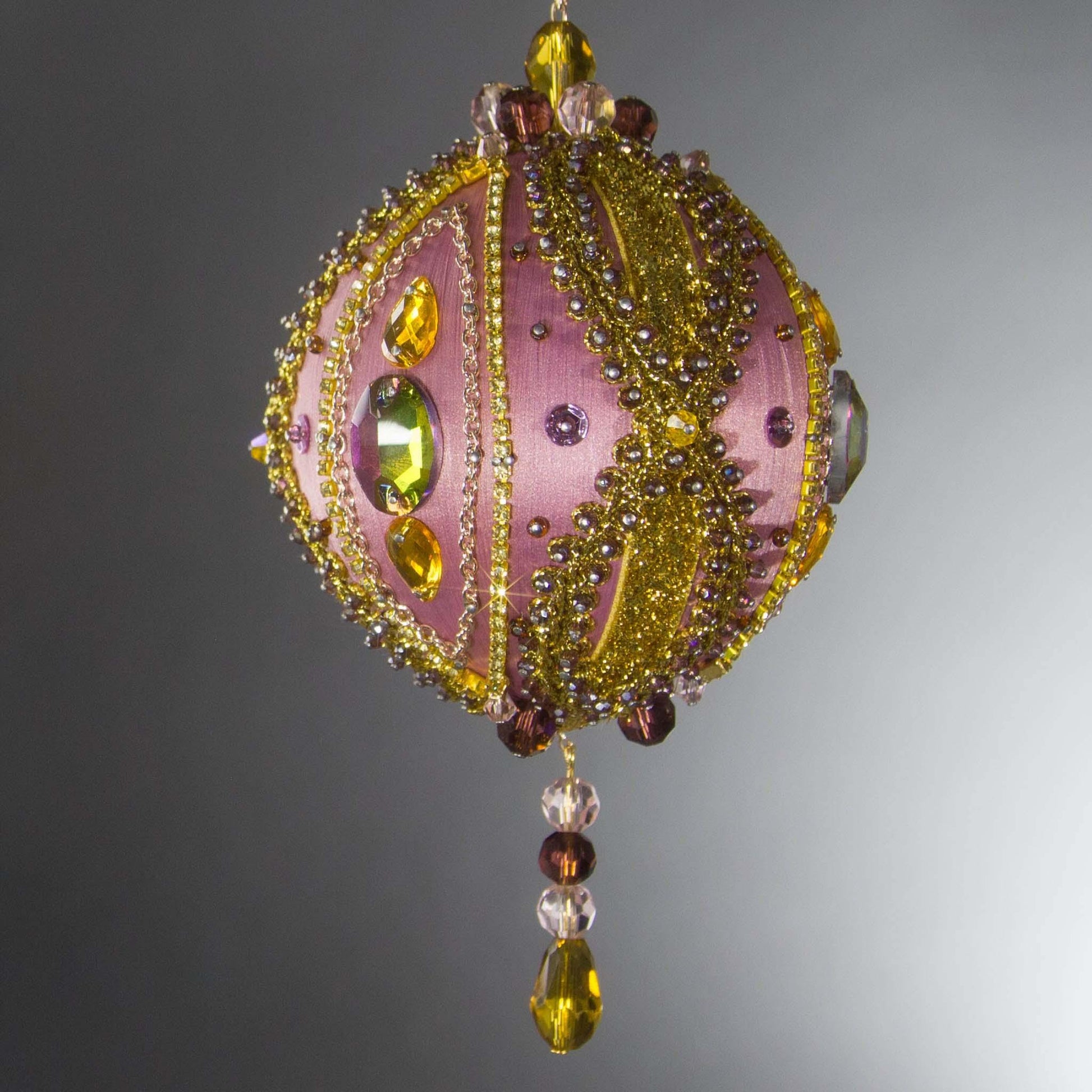 Christmas Beaded Ornament Kit Ball embellished with glass rhinestones, gold braided trim, and crystal beads. Side view. (Pale Violet Red).
