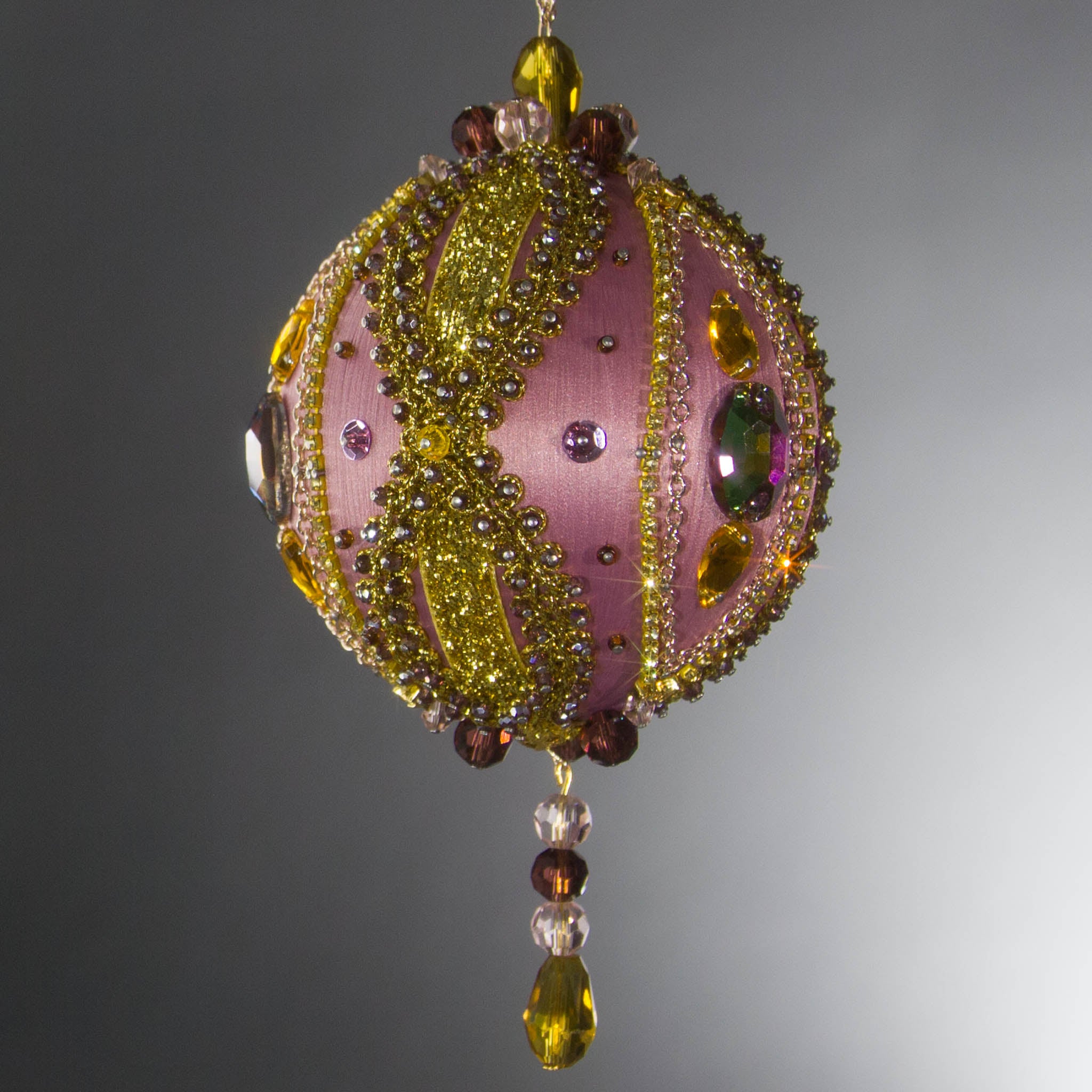 Christmas Beaded Ornament Kit Ball embellished with glass rhinestones, gold braided trim, and crystal beads. Side view. (Pale Violet Red).
