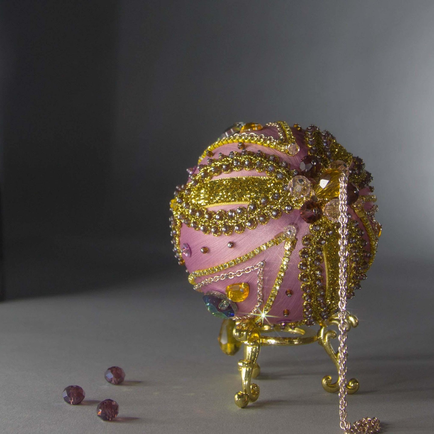 Christmas Beaded Ornament Kit Ball embellished with glass rhinestones, gold braided trim, and crystal beads. Top detail. (Pale Violet Red).