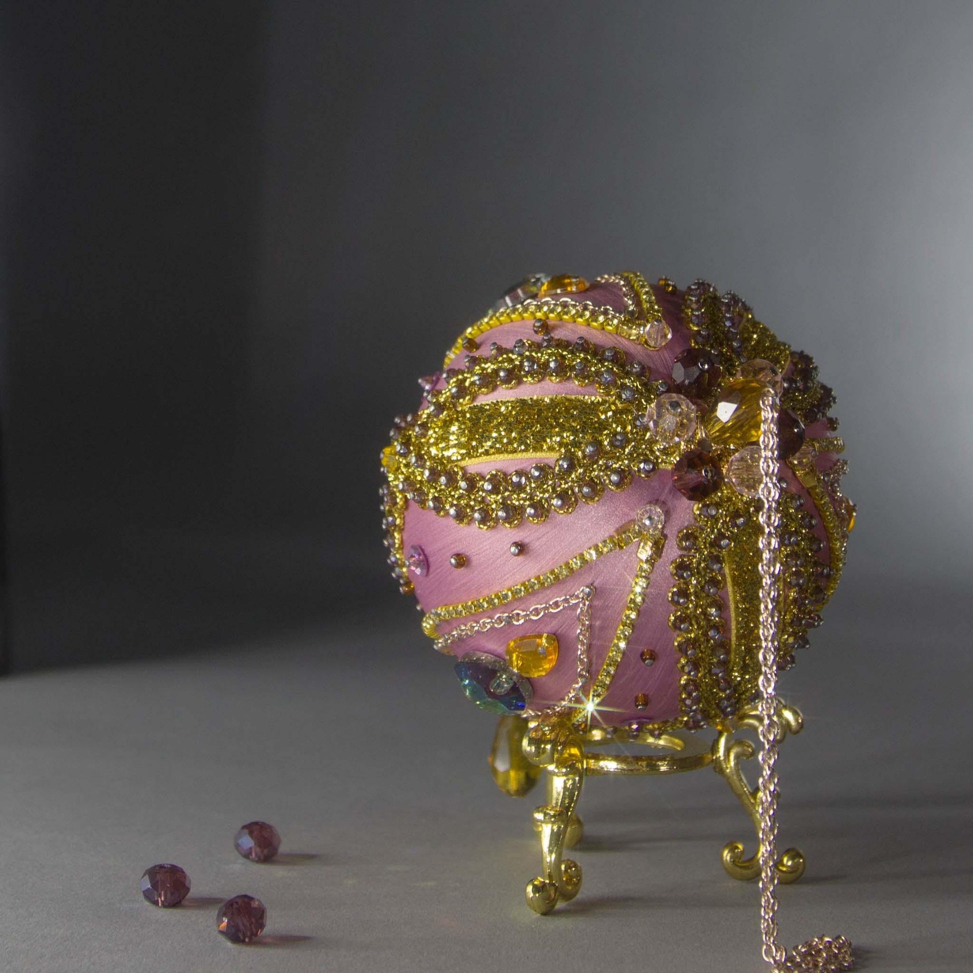 Christmas Beaded Ornament Kit Ball embellished with glass rhinestones, gold braided trim, and crystal beads. Top detail. (Pale Violet Red).