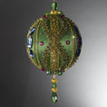 Load image into Gallery viewer, Christmas Beaded Ornament Ball embellished with large glass color-shifting rhinestones, gold braided trim, and crystal beads. Side view. (Olive).
