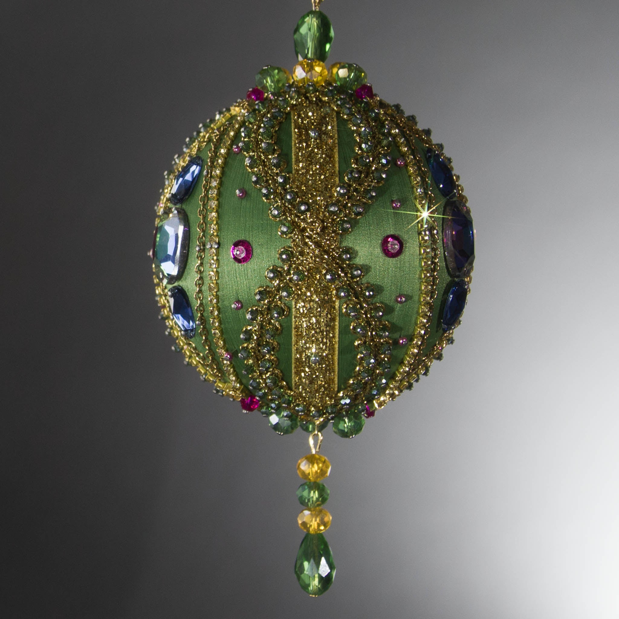 Christmas Beaded Ornament Ball embellished with large glass color-shifting rhinestones, gold braided trim, and crystal beads. Side view. (Olive).