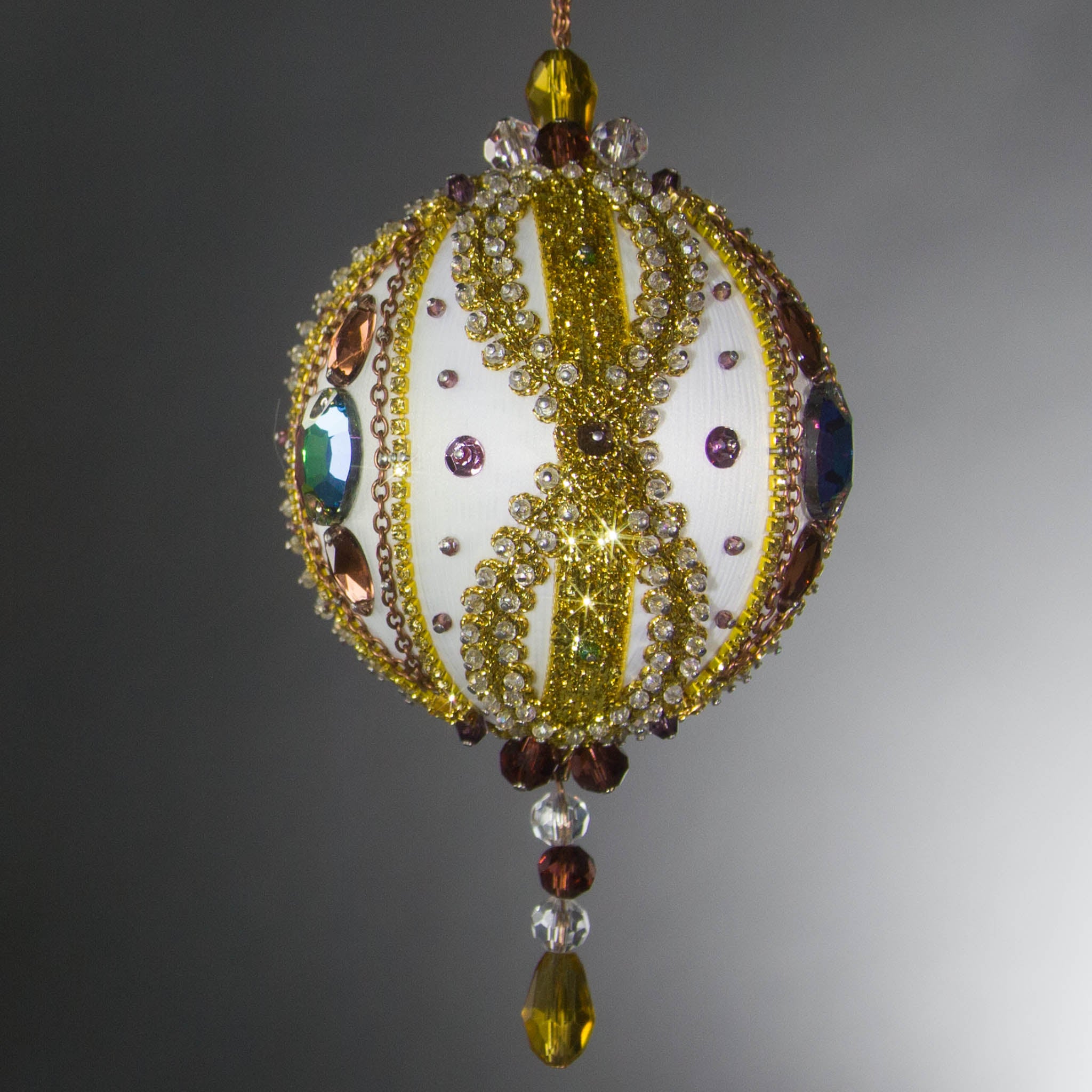 Handmade Satin Ornament by Whim5seasons embellished with glass rhinestones, gold braided trim, and crystal beads. Side view. (White).