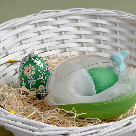 Green Easter egg push pin ornament kit with floral patterns inside a transparent box on straw with a white woven basket background. (Green)