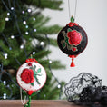 Load image into Gallery viewer, Decorative Christmas ornaments with red roses on a blurred Christmas tree background.
