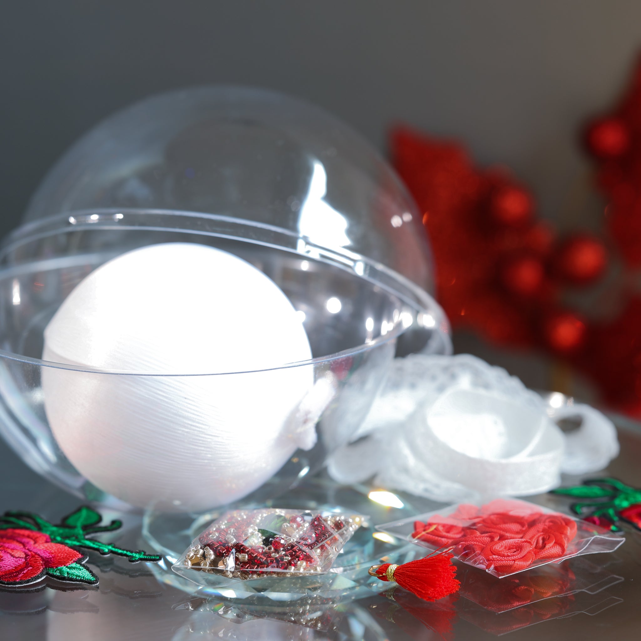 White satin ball and packets of beads, miniature roses, red tassel, with a clear storage container. (White)