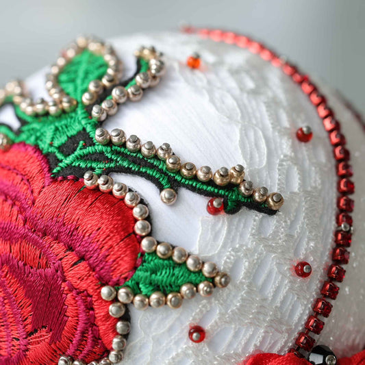 A close up of a handmade push pin ornament showing small gold beads  pinned to a satin ball with dressmaker pins by Whim5season.