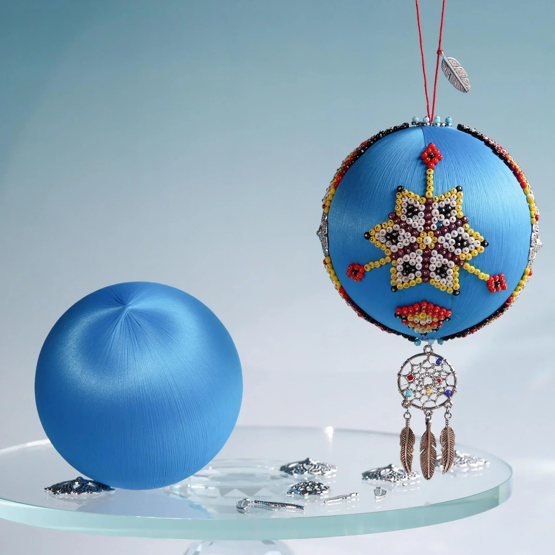 Large bright blue 4" satin ball for the DIY Christmas push pin ornament project, and a completed handmade beaded ornament ball colorful indigenous design and a dream catcher charm tassel by Whim5seasons.