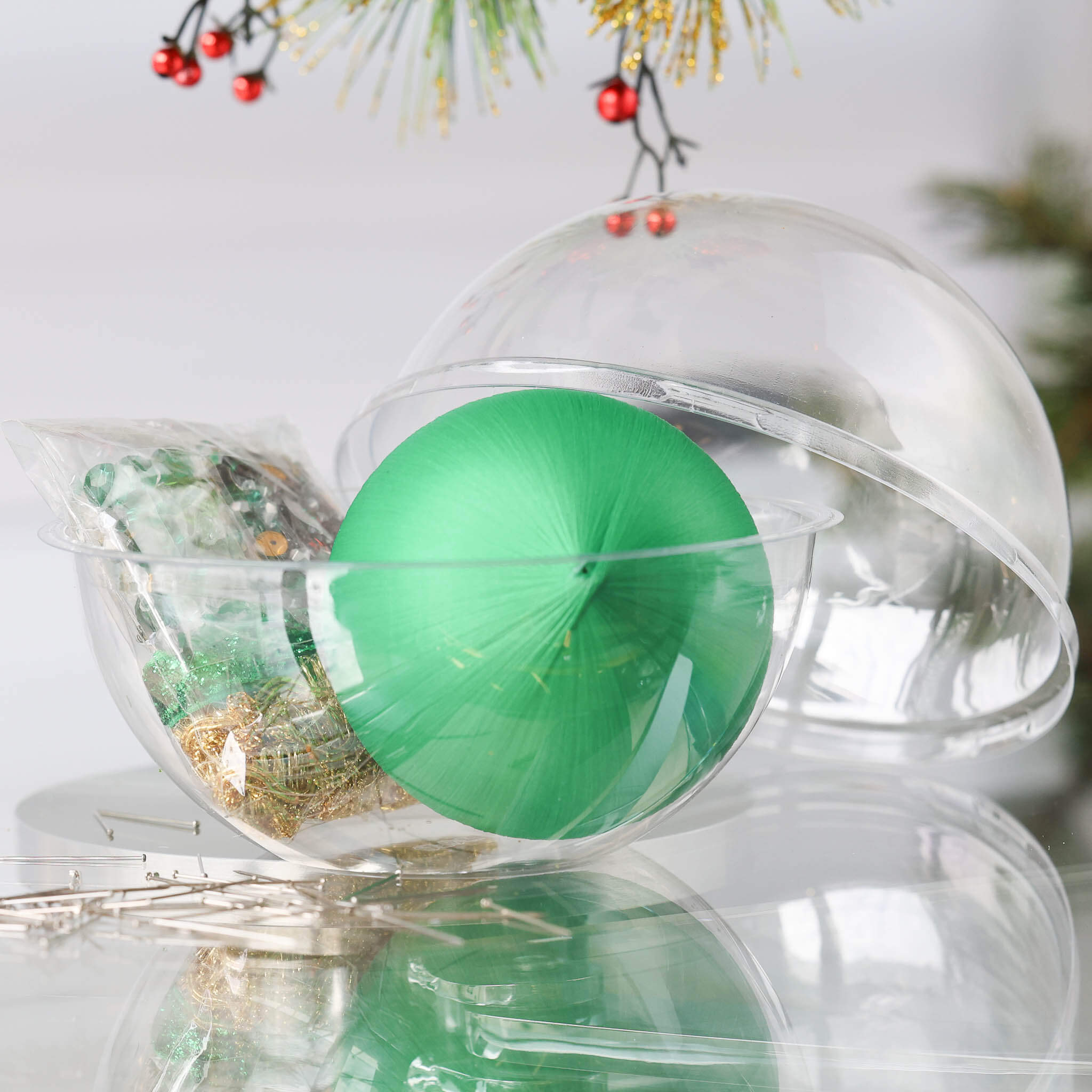 DIY Zima Ornament Kit with a green satin foam core in a clear plastic container with other push pin kit materials in a small clear bag  on a white background. (Green)