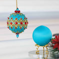 Load image into Gallery viewer, Push pin ornament kit showcasing a finished bright teal-colored handmade Christmas ornament with red rhinestones and a satin foam core for crafting another ornament. (Light Sea Green)
