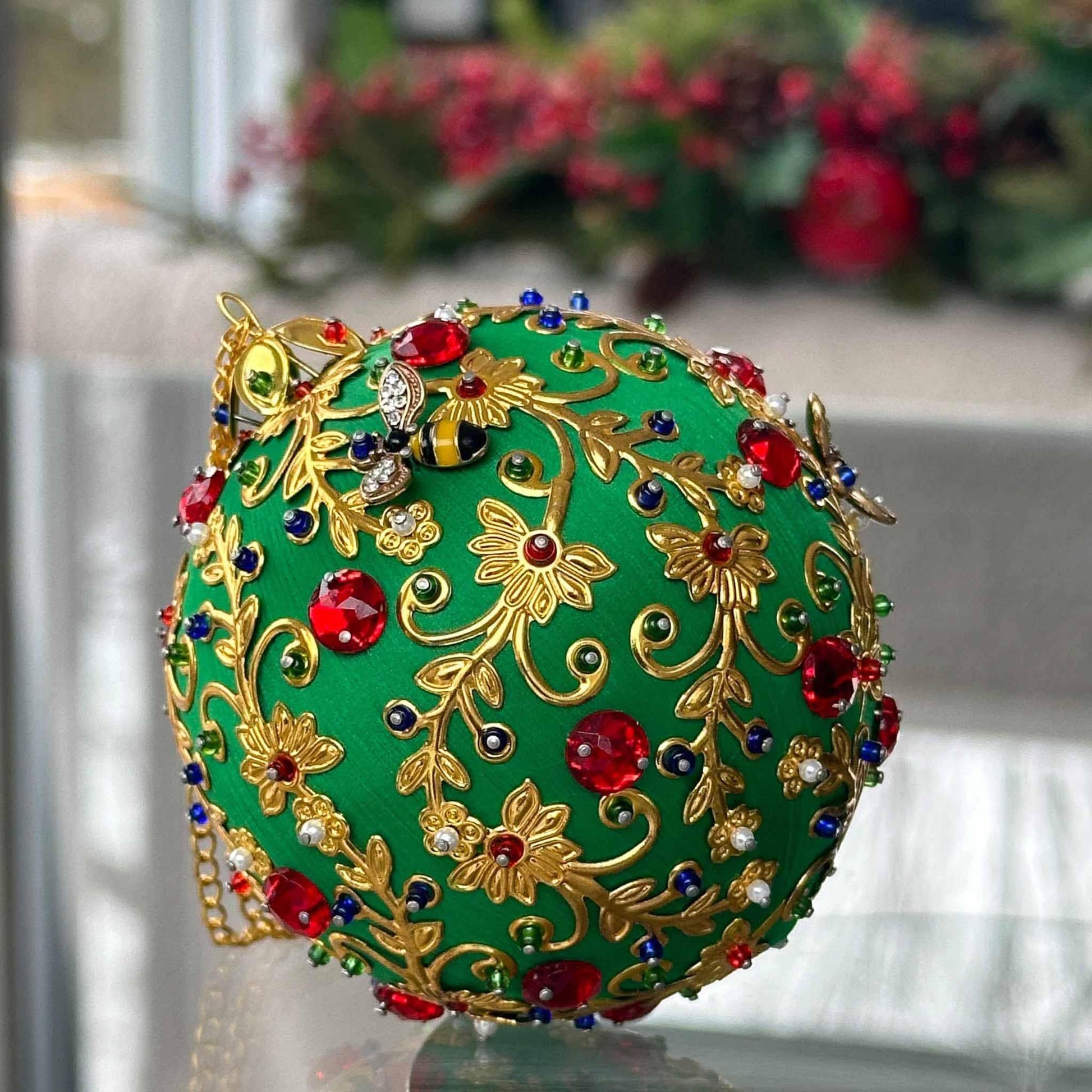 Quam Handmade Christmas Push Pin  Ornament in Green with gold metal embellishments and red rhinestones in front of evergreen branch by Whim5seasons.