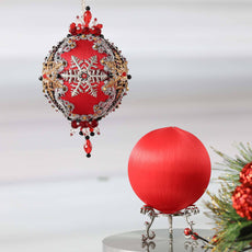Two satin balls - one is a completed push pin ornament, and the other is a green foam base to be used for a DIY craft project.  (Red)