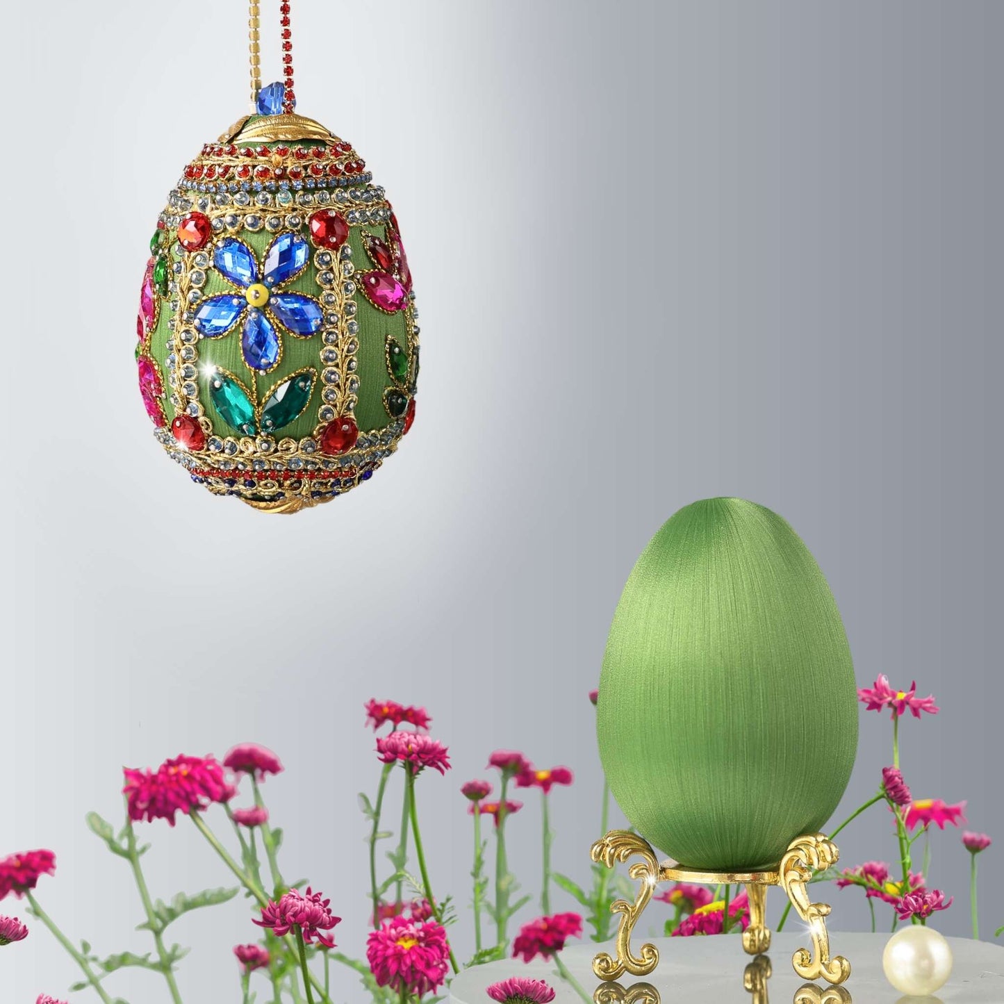 Decorative handmade green Easter egg with colorful gemstones hanging on a red rhinestone chain and a luxurious satin foam base on a stand against a light gray background by Whim5seasons.