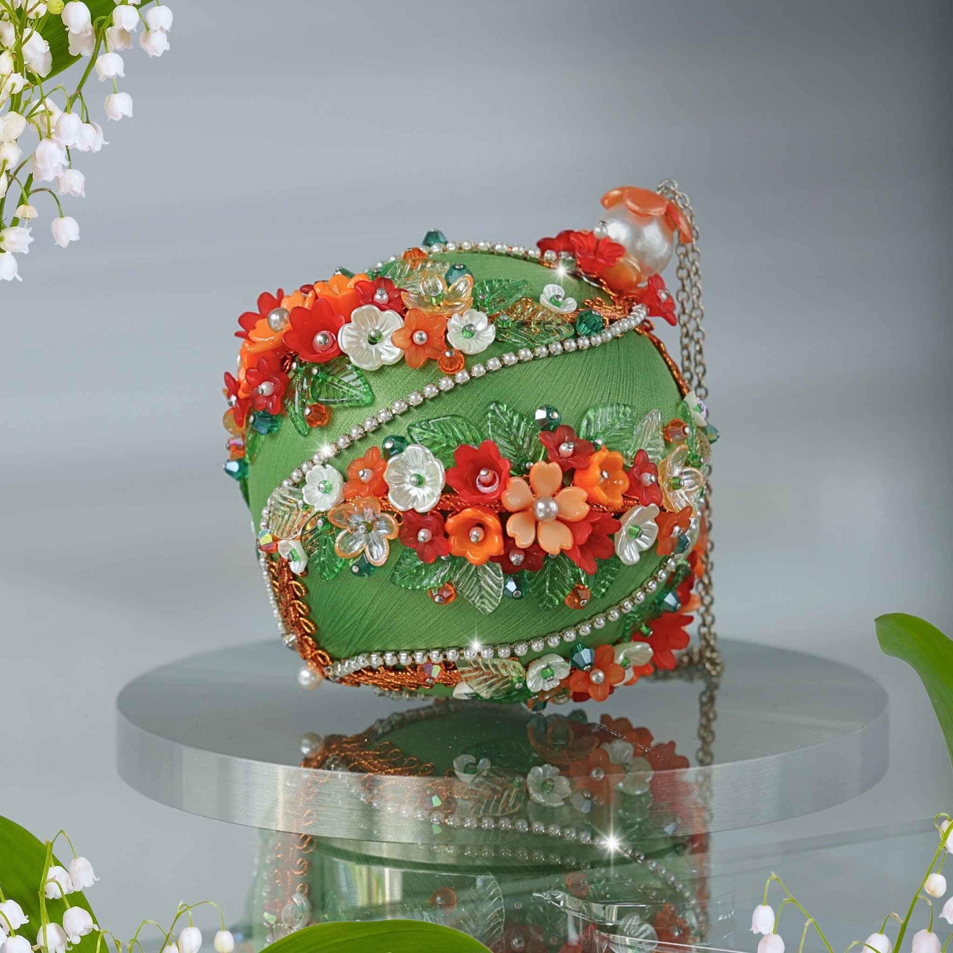 Side view of a hand crafted satin Christmas ornament adorned with mini flower charms, contrasting color trims, and metallic accents by Whim5seasons.