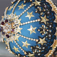 Load image into Gallery viewer, A close-up of dark purple beads and gold star-shaped sequins on a dark teal satin foam core ball featuring a completed handmade push pin ornament set against a dark gray background. (Dark Slate Blue)
