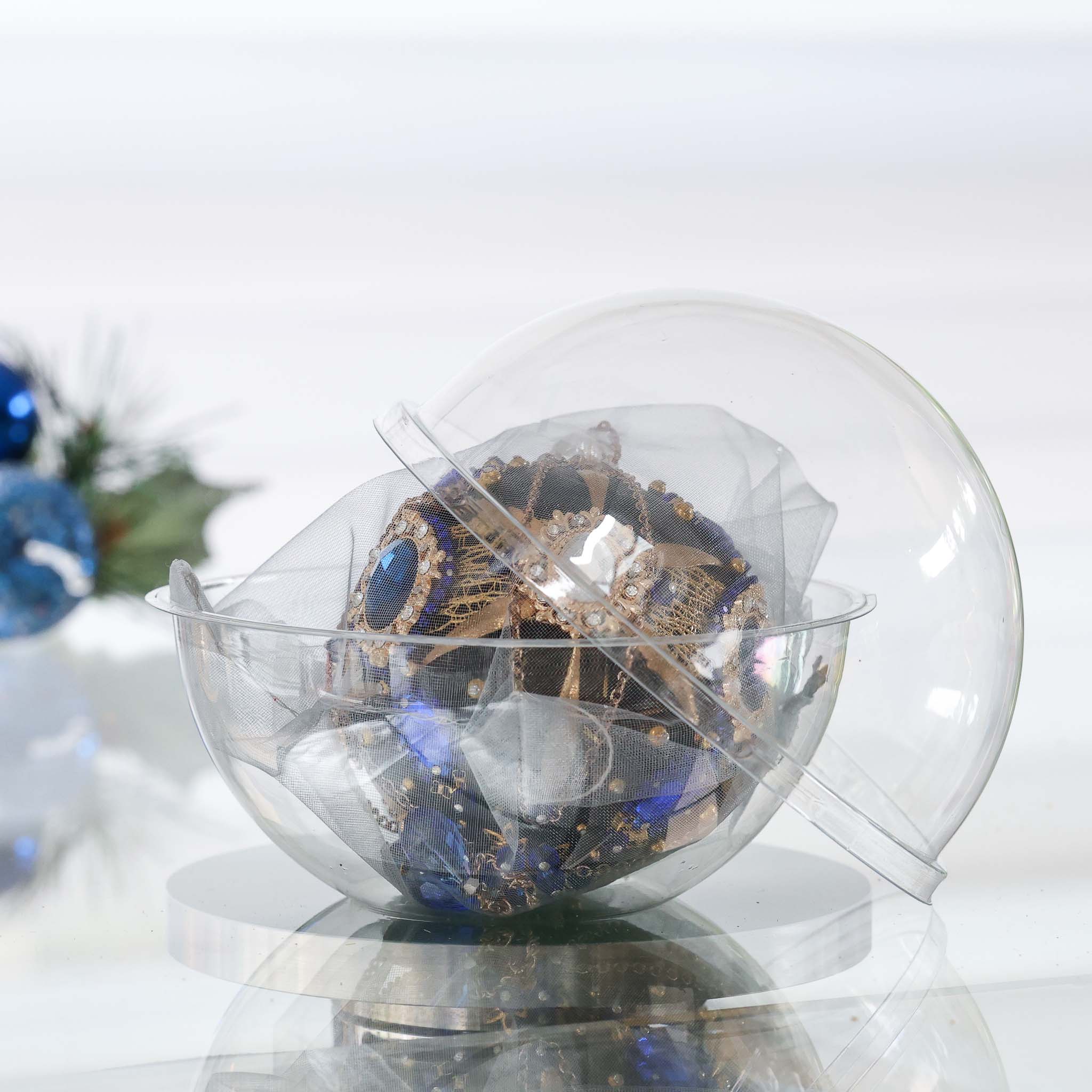 Handmade mid century style black satin push pin ornament featuring large cameos, blue rhinestones, and gold beads in a clear storage container with a Christmas branch in the background by Whim5seasons. (Black)