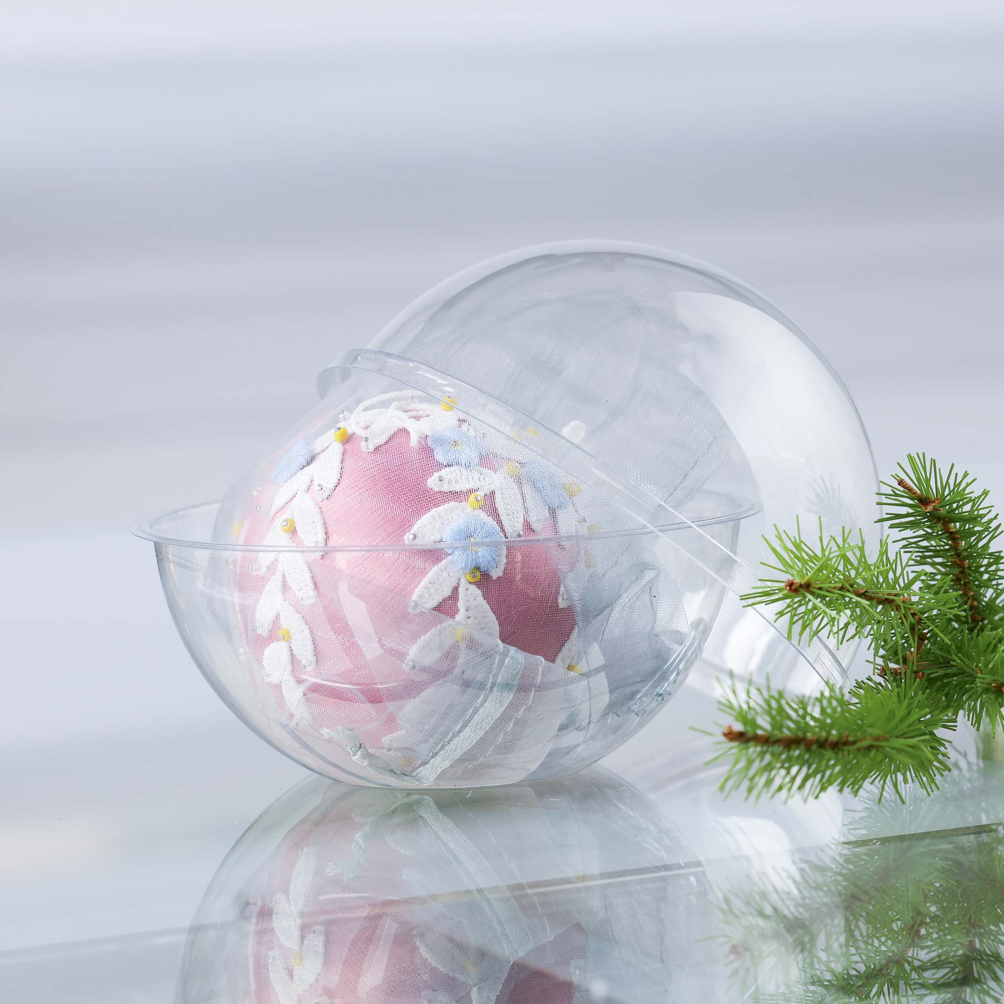 Vintage style Frosted Laurel Ornament Kit in a clear plastic container with a on a white background with holiday greenery. (Pale Violet Red)
