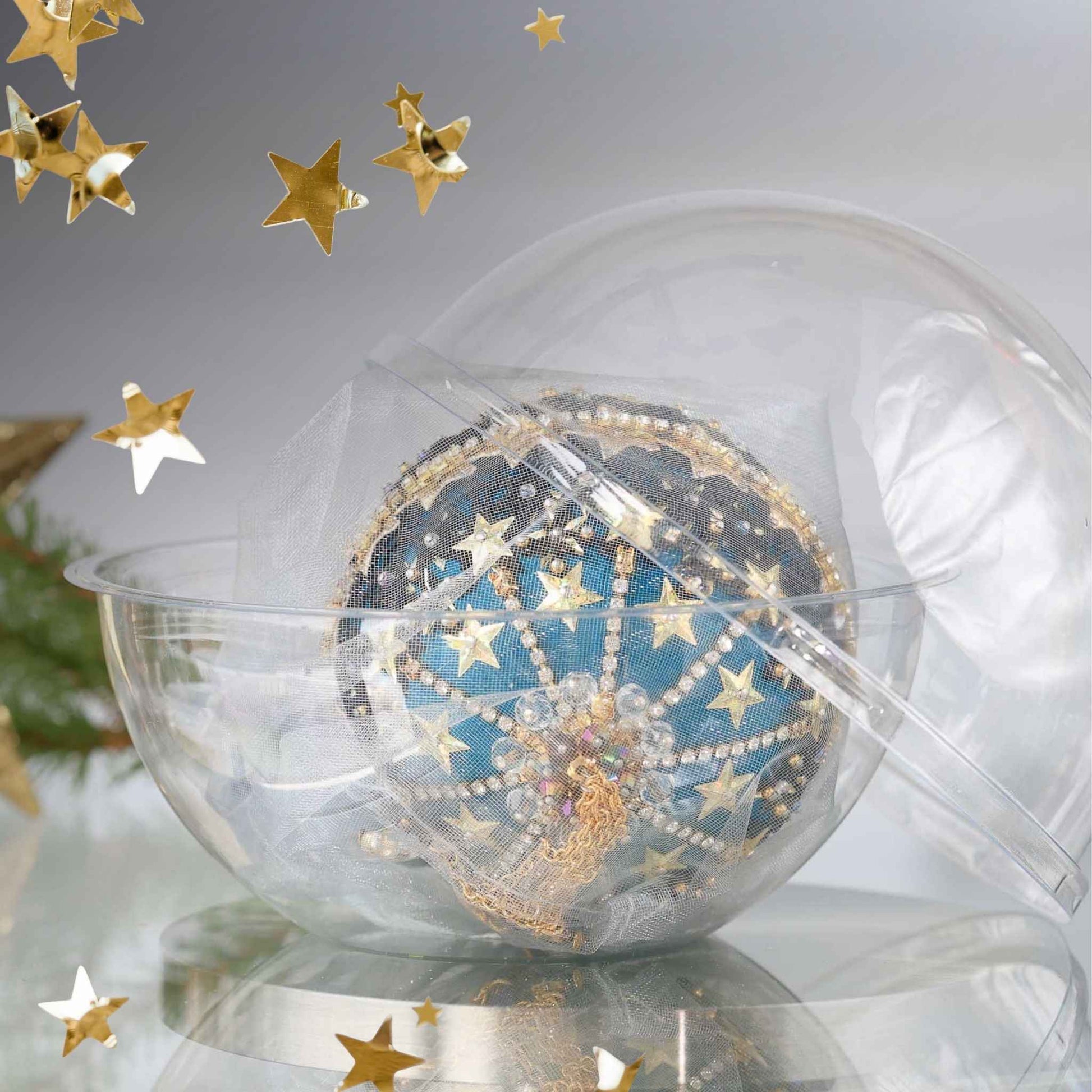 Completed Handmade Christmas Push Pin Ornament in a dark teal color with gold star design in a storage container set against a light background with a gold star and holiday greenery by Whim5seasons.