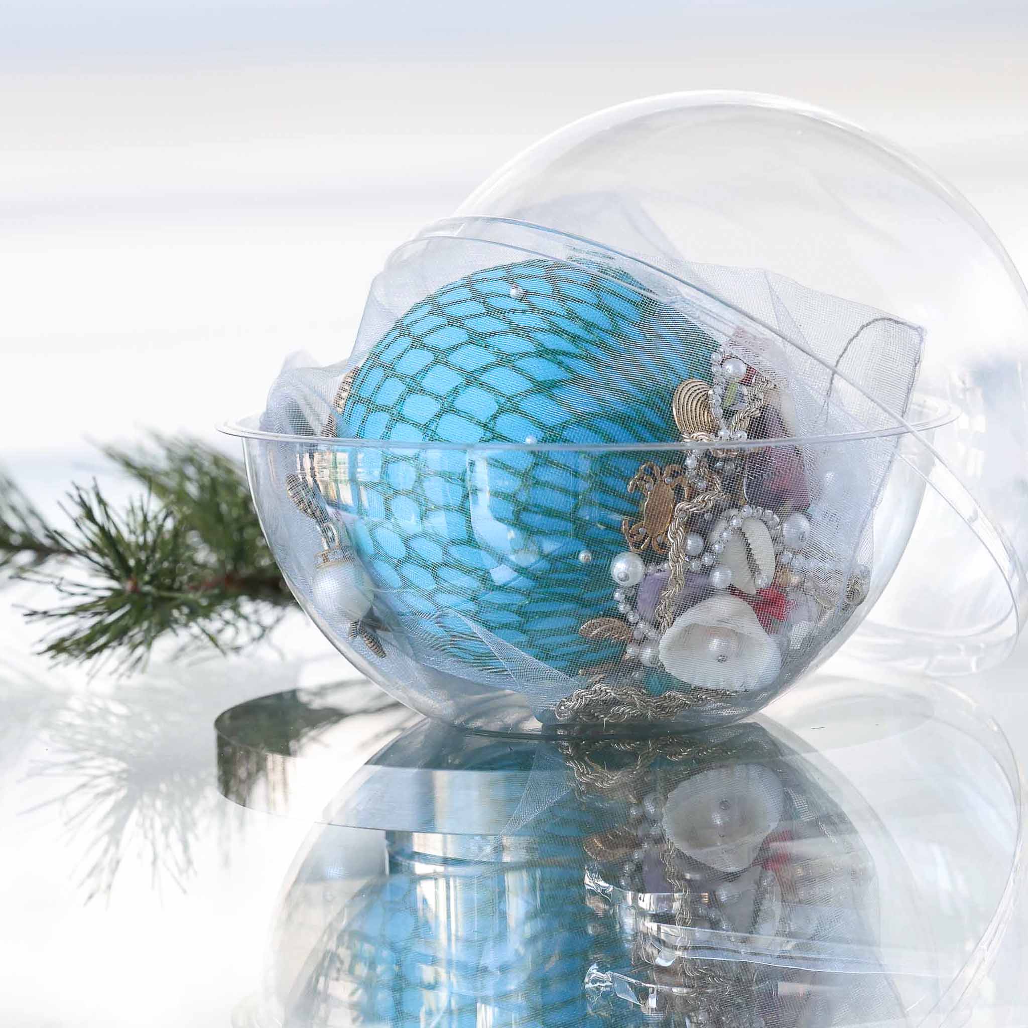 Handmade sequin & beaded teal-colored satin ornament inside a round plastic storage container with holiday greenery by Whim5seasons.